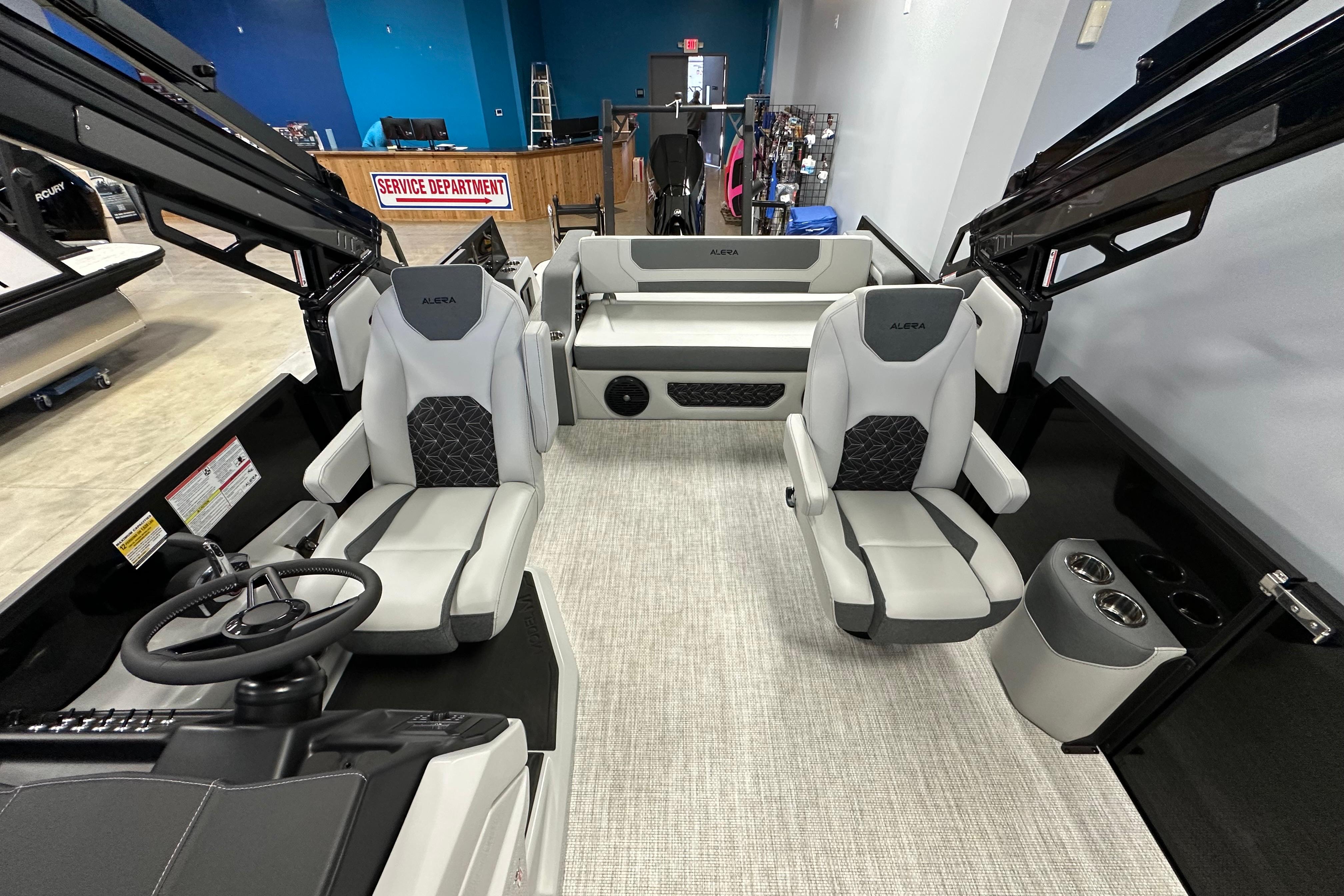 Interior of 2026 Alera M25L boat with modern seating and steering wheel.