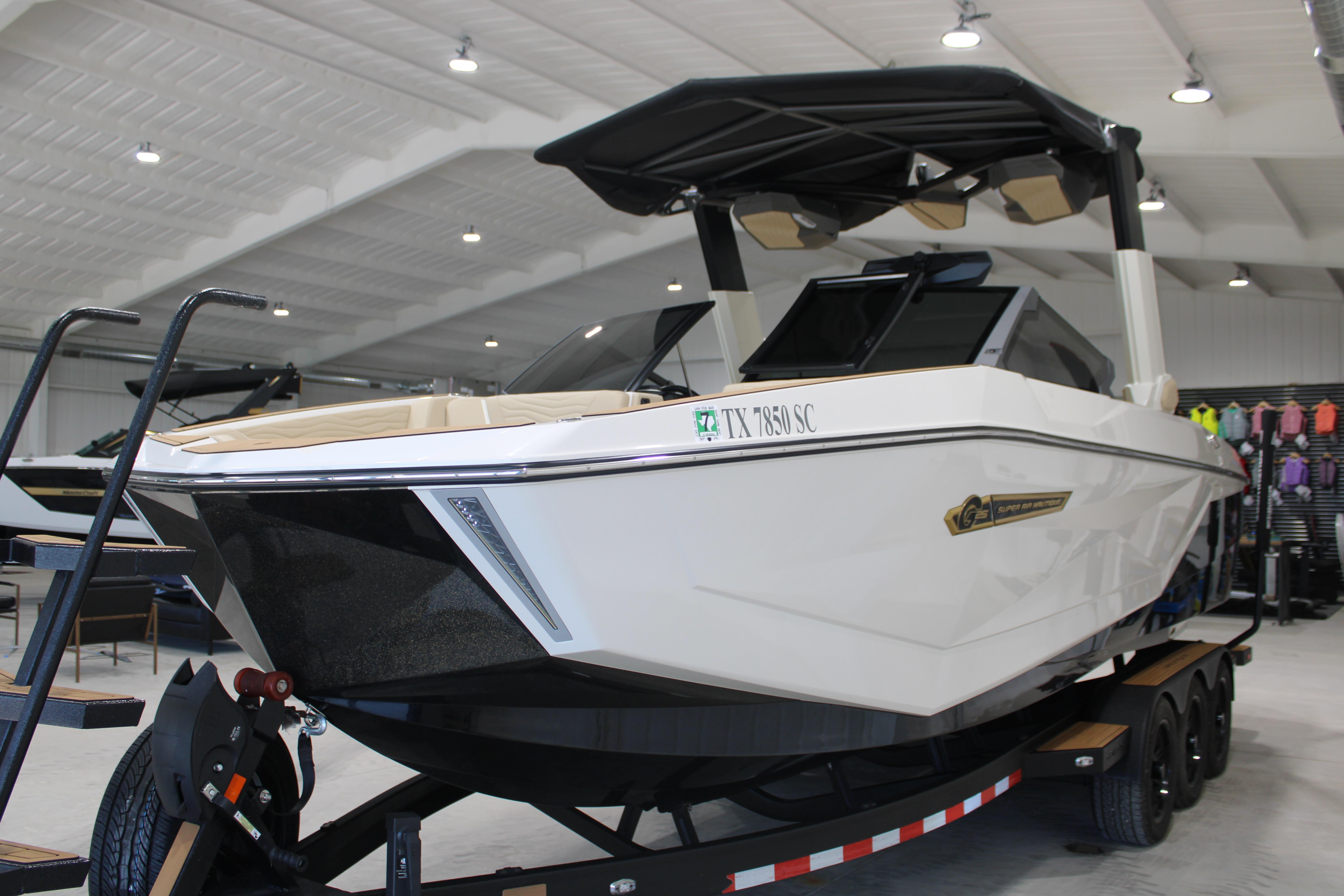 2025 Nautique Super Air Nautique G25 boat in showroom, on trailer, under bright lighting.