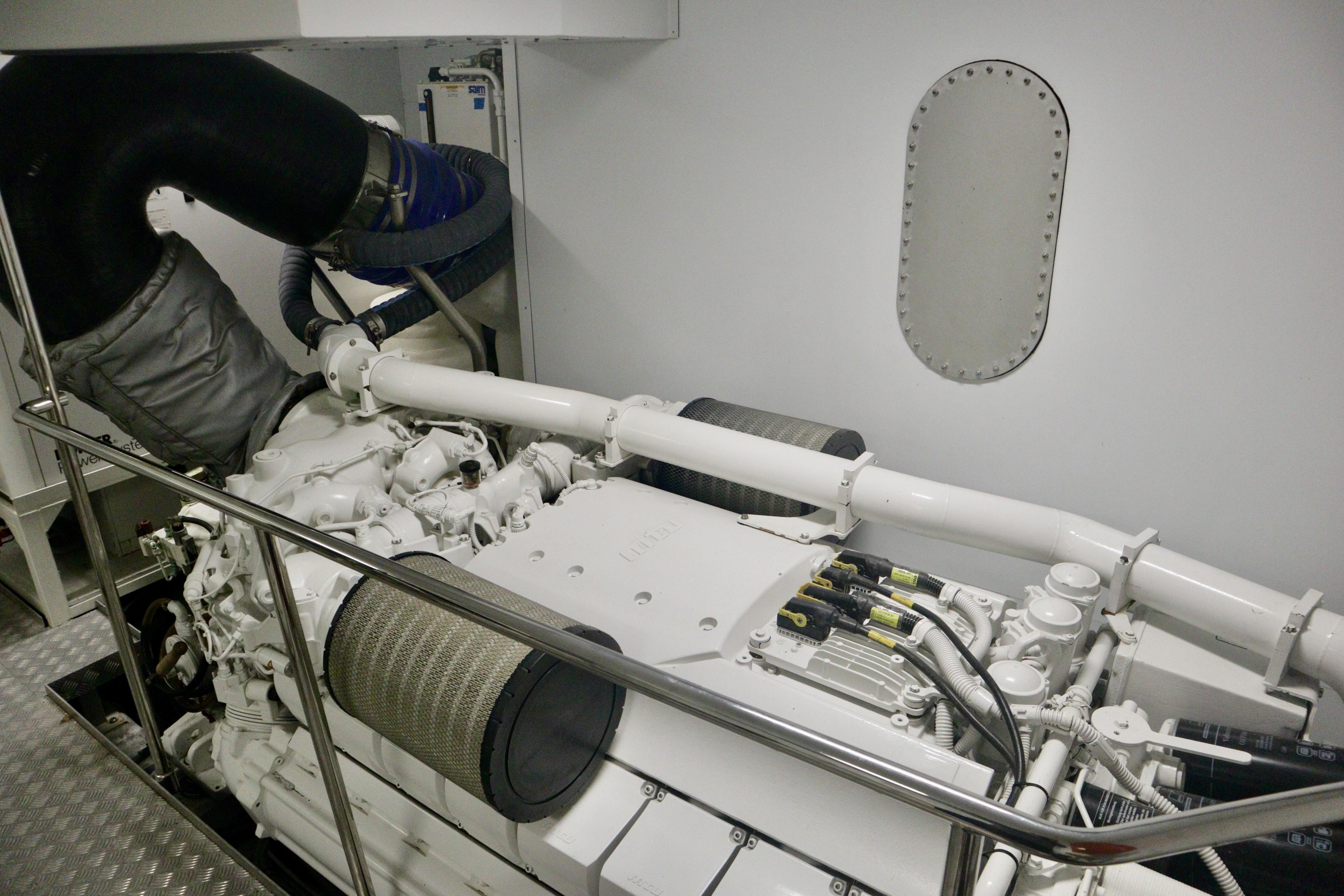 Engine room of 2016 Custom Line 97 yacht, showcasing mechanical components and piping.