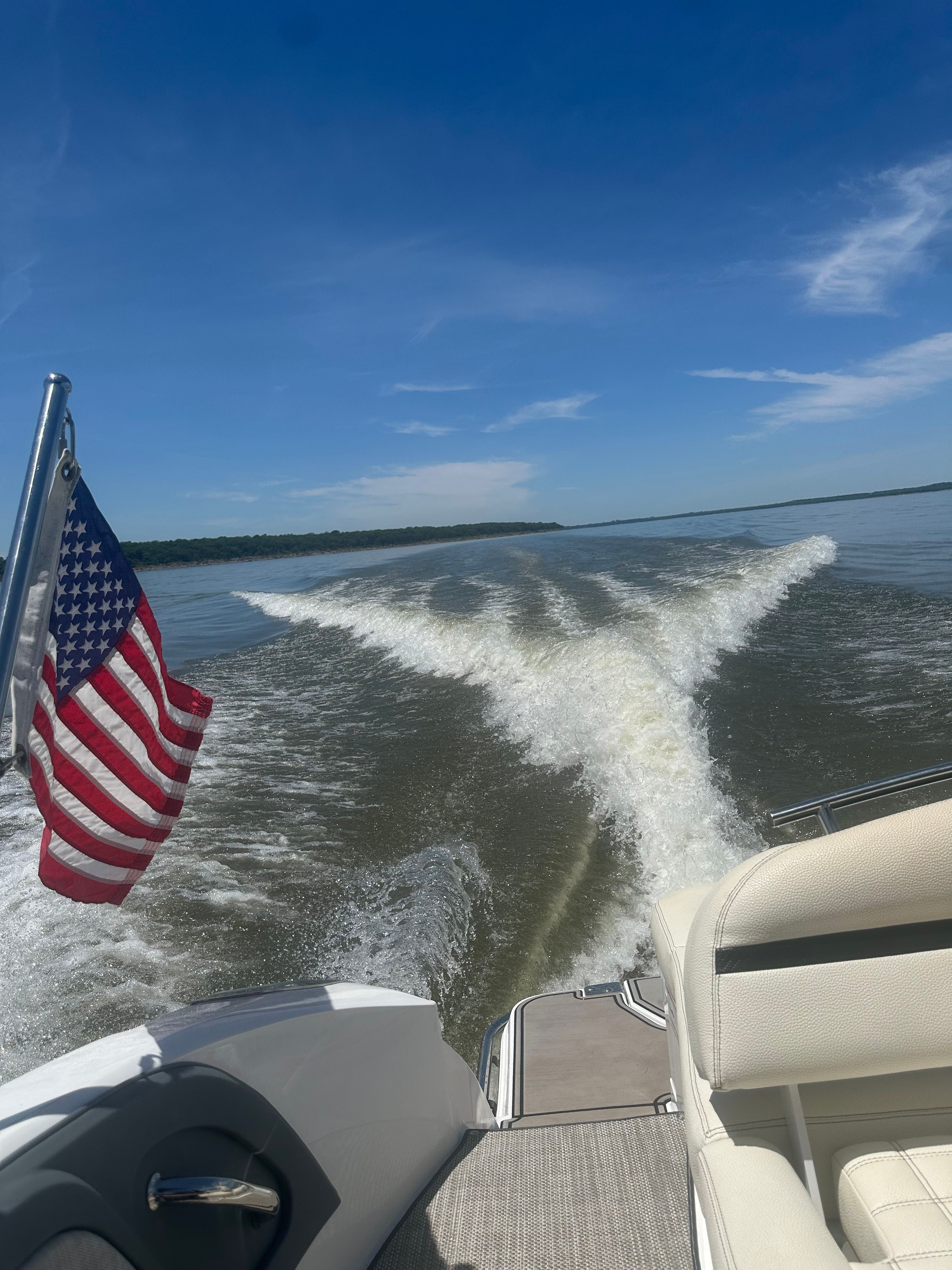 A 2019 Cobalt R7 Surf boat on a lake, leaving a V-shaped wake in the water.