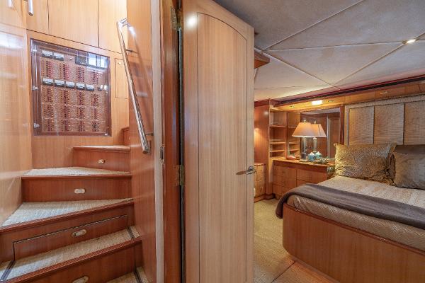 Luxurious interior of 2001 Grand Harbour 76 yacht with wooden stairs and cozy bedroom.