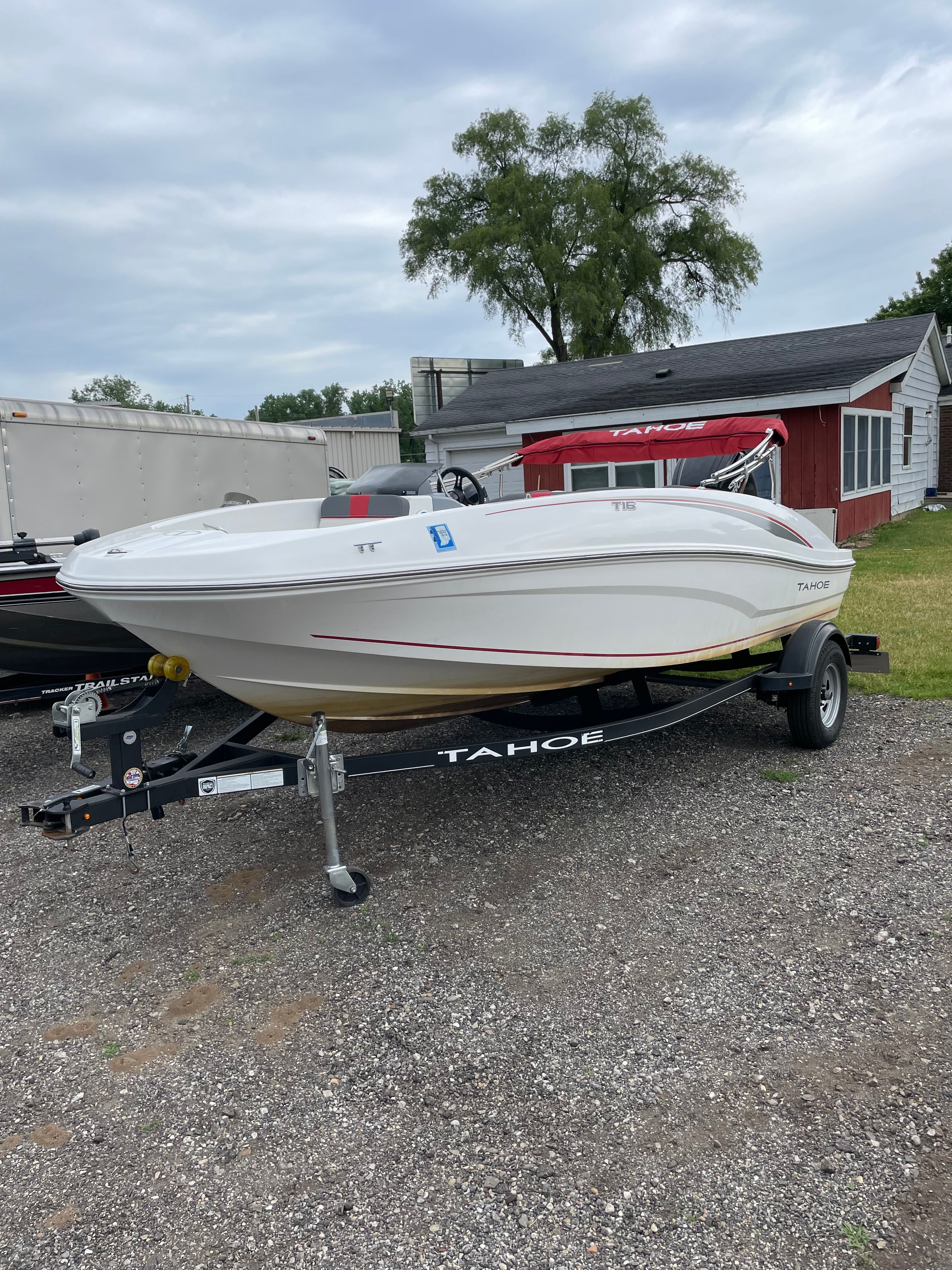 2022 Tahoe T16 boat on trailer, parked outdoors.