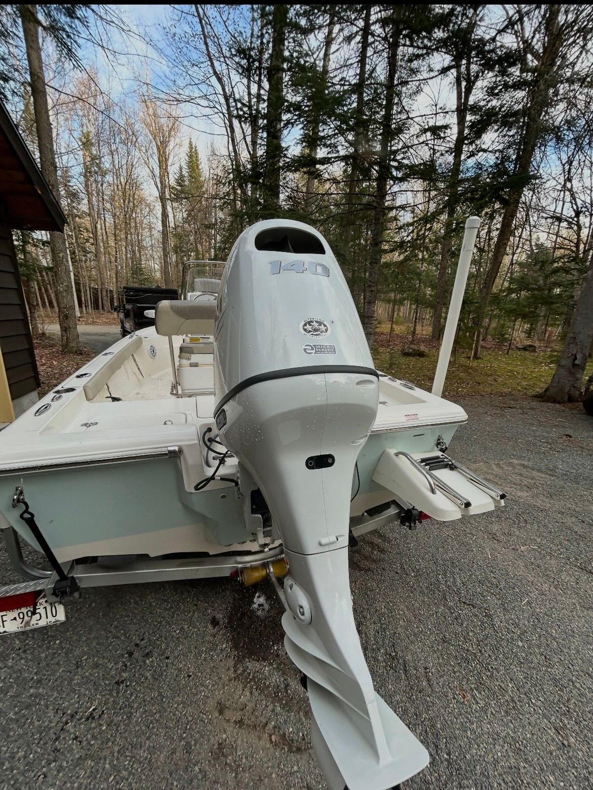 2023 Key West 188 Bay Reef boat with outboard motor in forest setting.