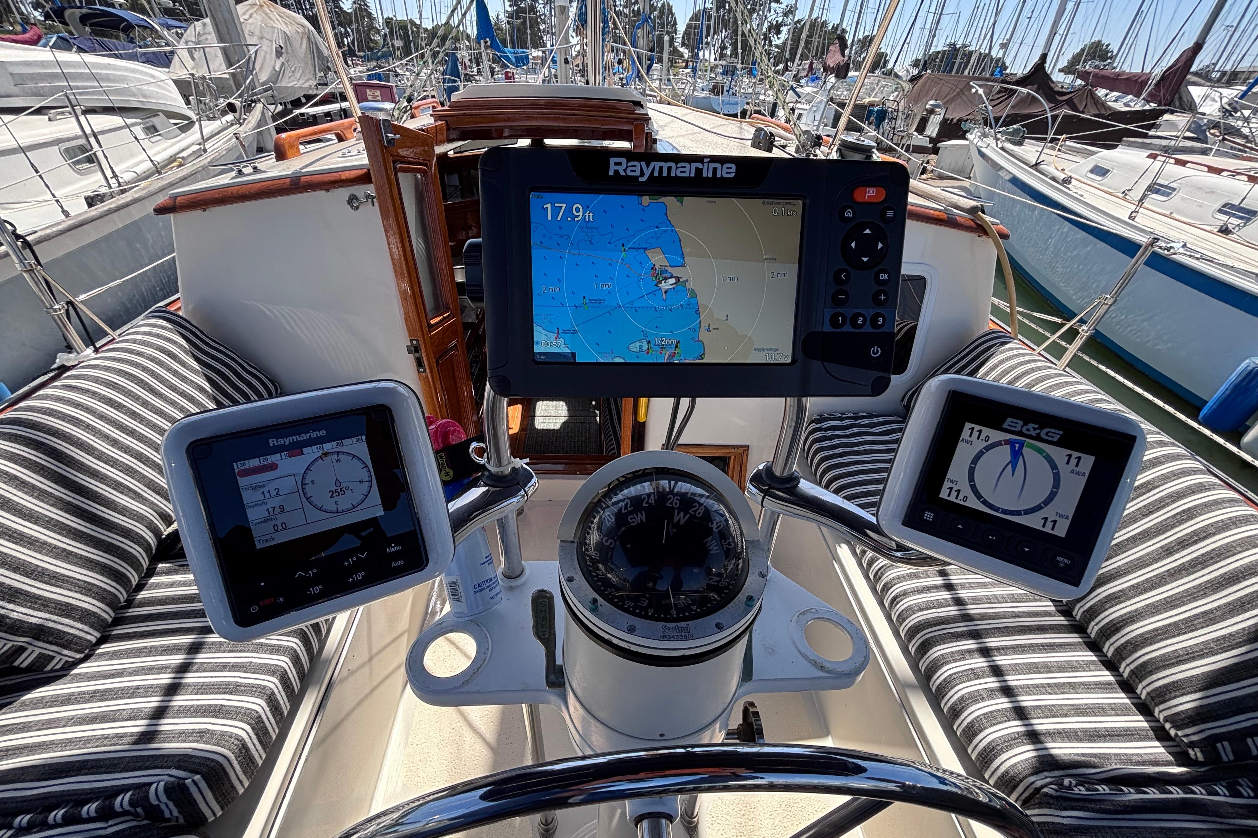 Cockpit of a 1978 Swift 33 sailboat with navigation instruments and striped seating.