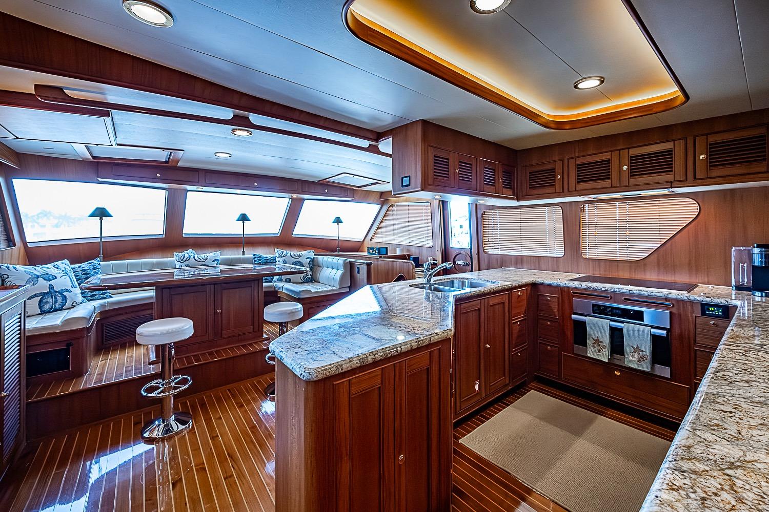 Luxurious interior of 2014 Marlow 80 Explorer yacht with elegant wood finishes and modern kitchen.