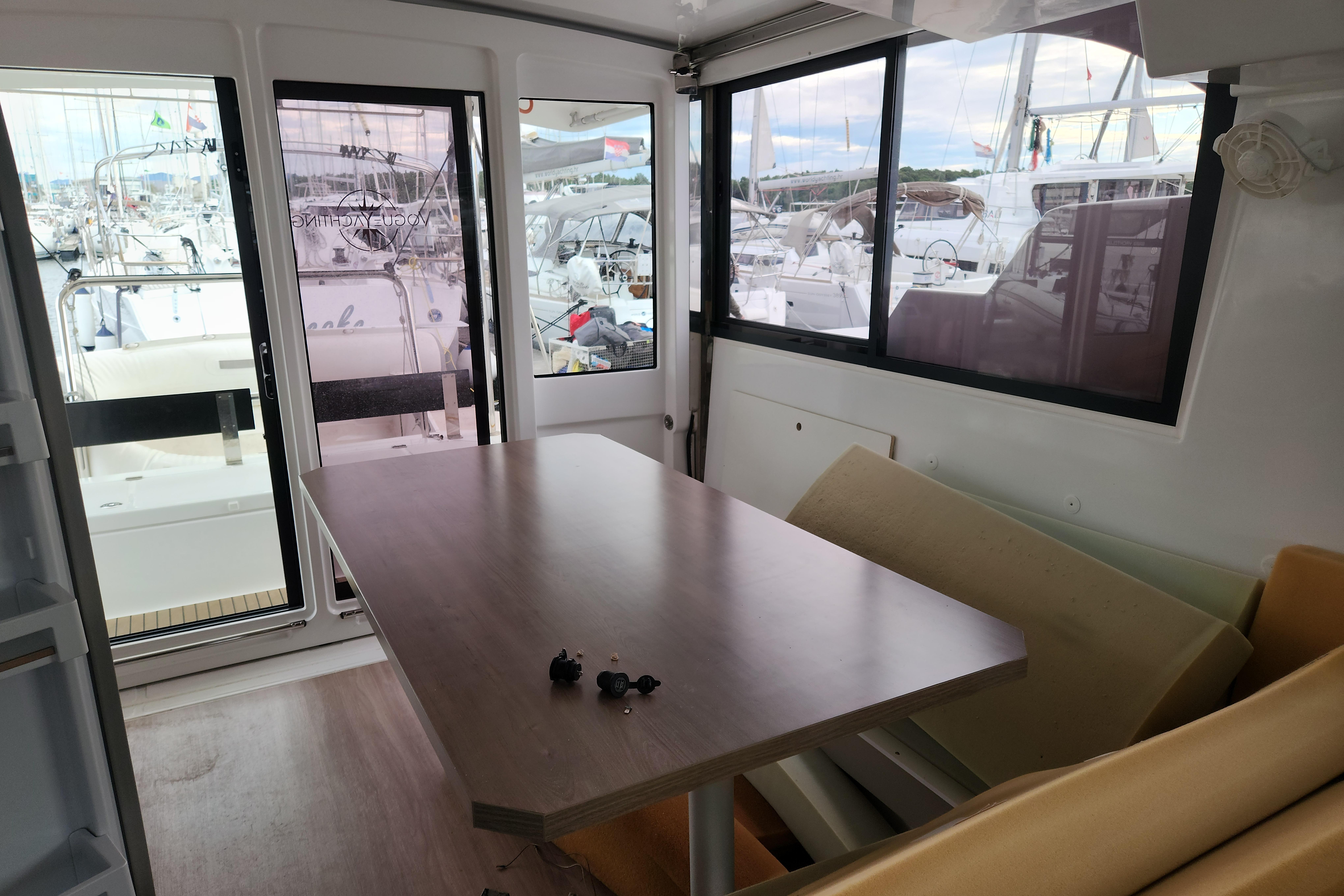 Interior of 2023 Bali Catspace 40 catamaran with table and marina view.