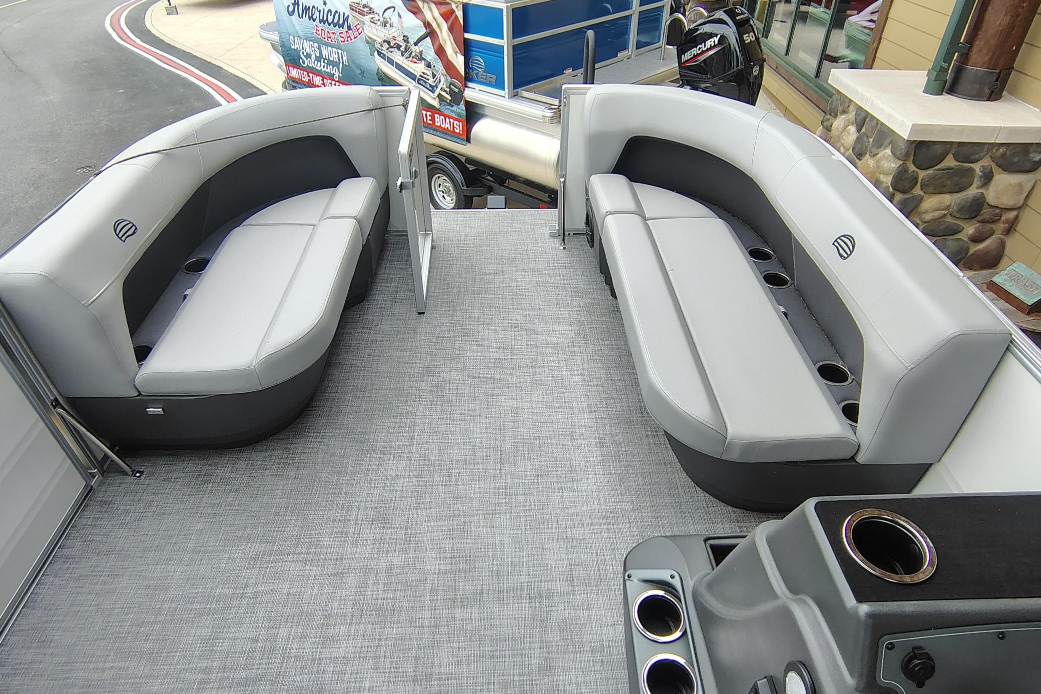 2026 Sun Tracker Party Barge 16 DLX interior with gray seating and cup holders.