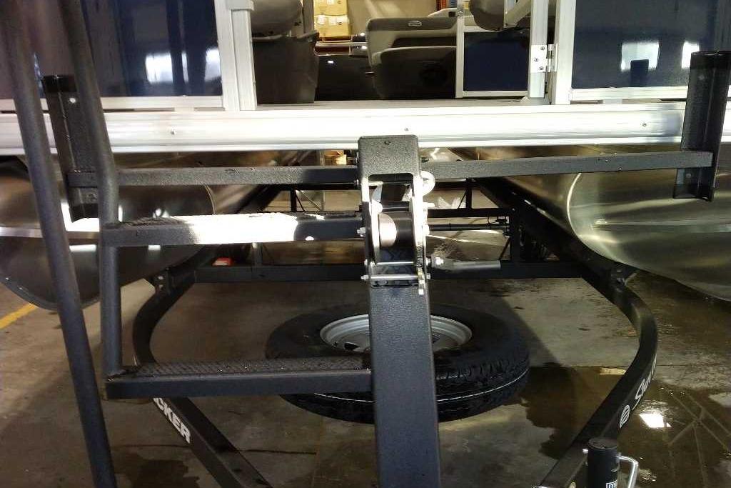 2026 Sun Tracker Bass Buggy 18 DLX pontoon boat on trailer in garage.