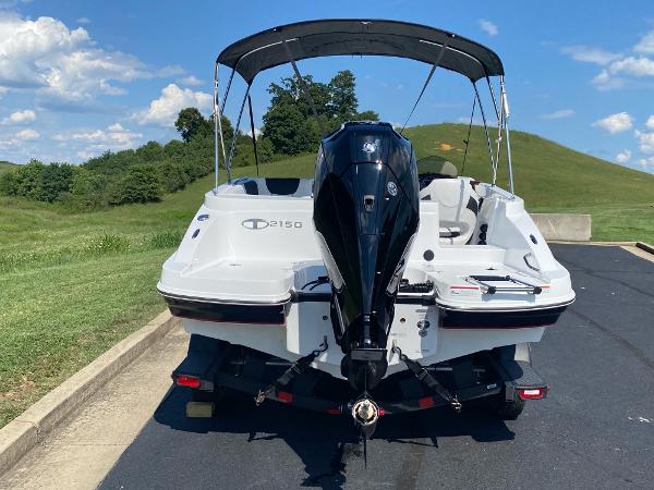 2024 Tahoe 2150 boat with outboard motor on trailer, parked on sunny day.