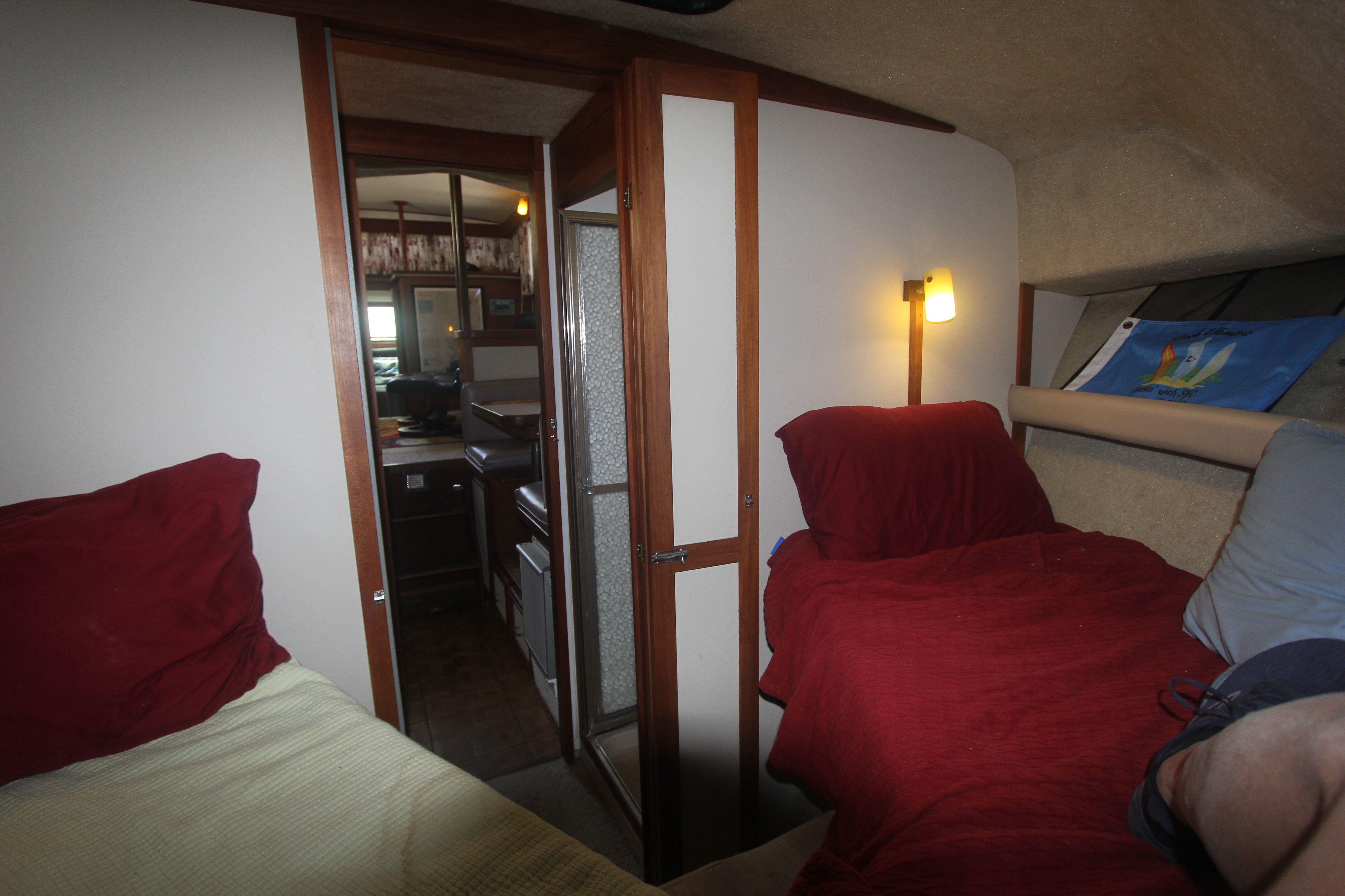 Interior of a 1988 Carver 3607 Aft Cabin Motor Yacht with cozy beds and lighting.