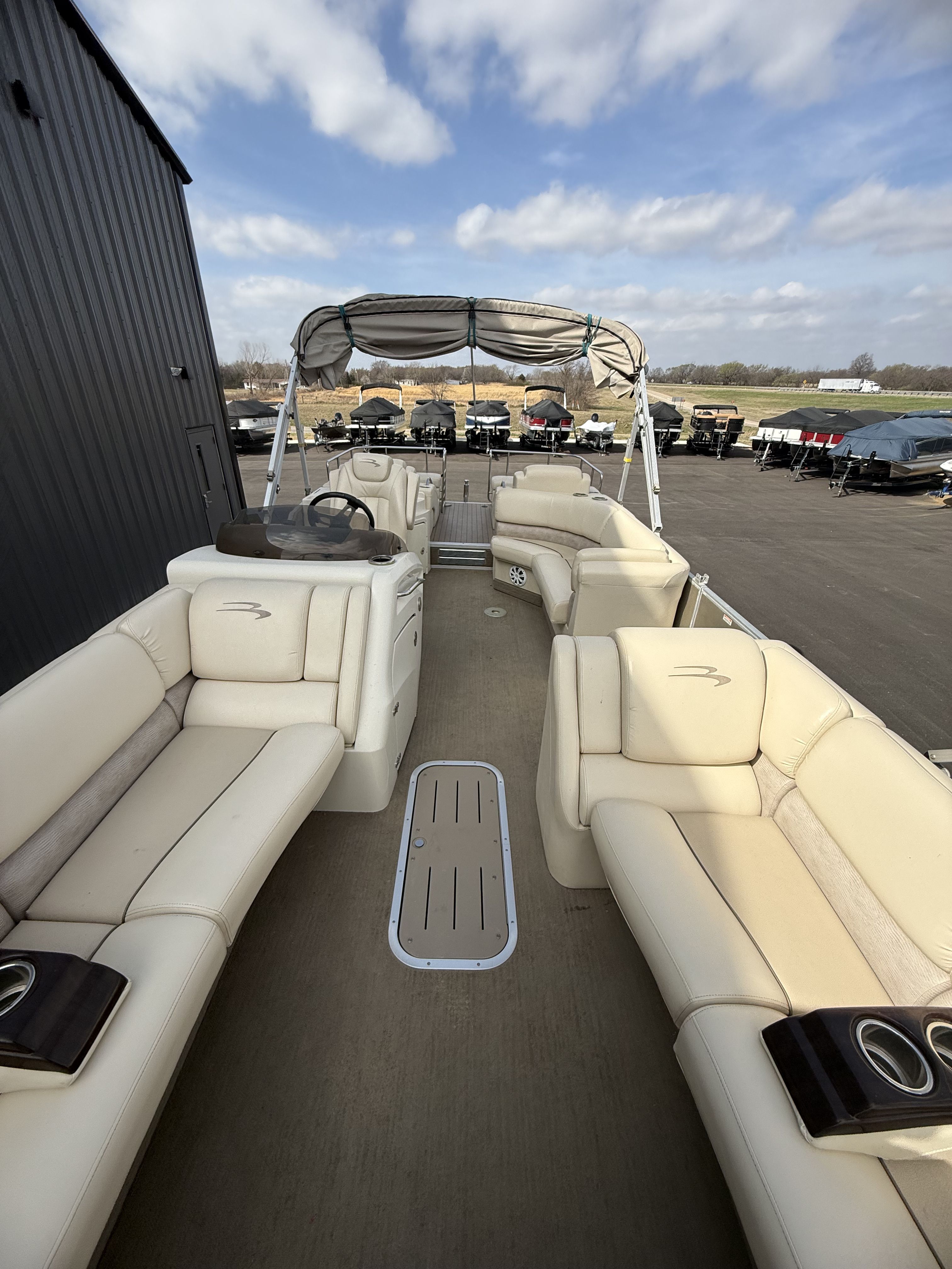 2014 Bennington 2575RCW-I/O pontoon boat with beige seating and canopy.