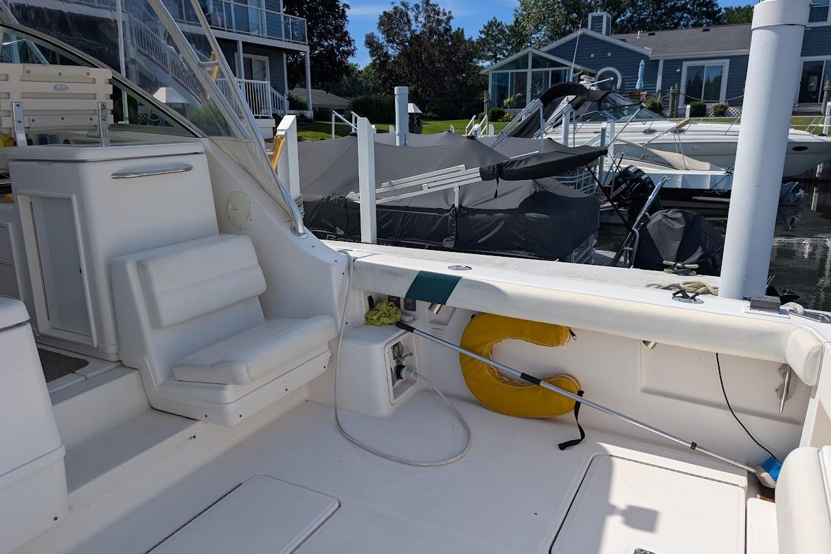 2000 Pursuit 3400 Express boat interior at marina, featuring white seating and safety equipment.