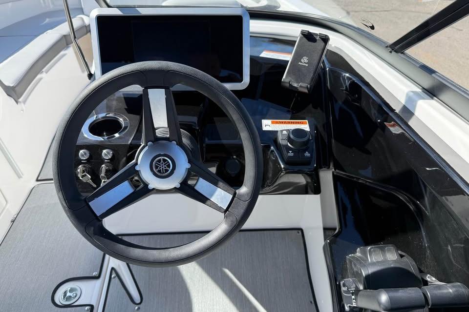 Steering wheel and dashboard of 2026 Yamaha Boats AR250, featuring modern controls and display.