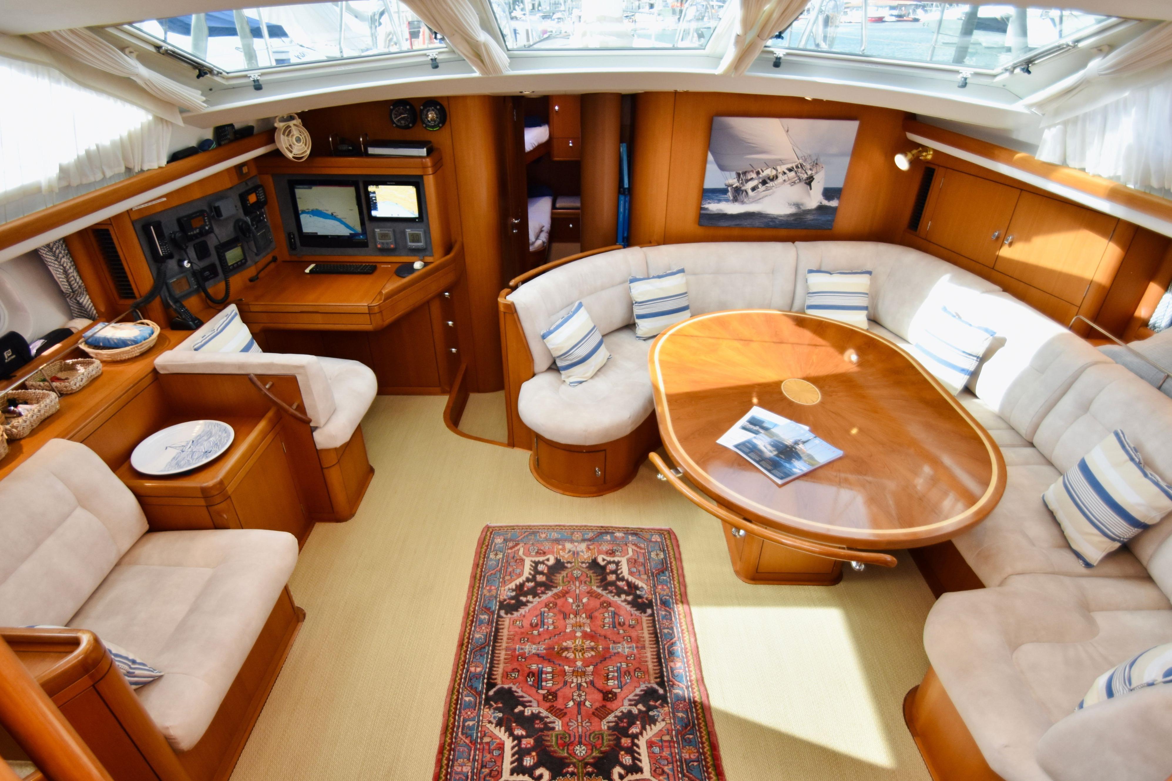 Luxurious interior of a 2005 Oyster 62 yacht with plush seating and navigation equipment.