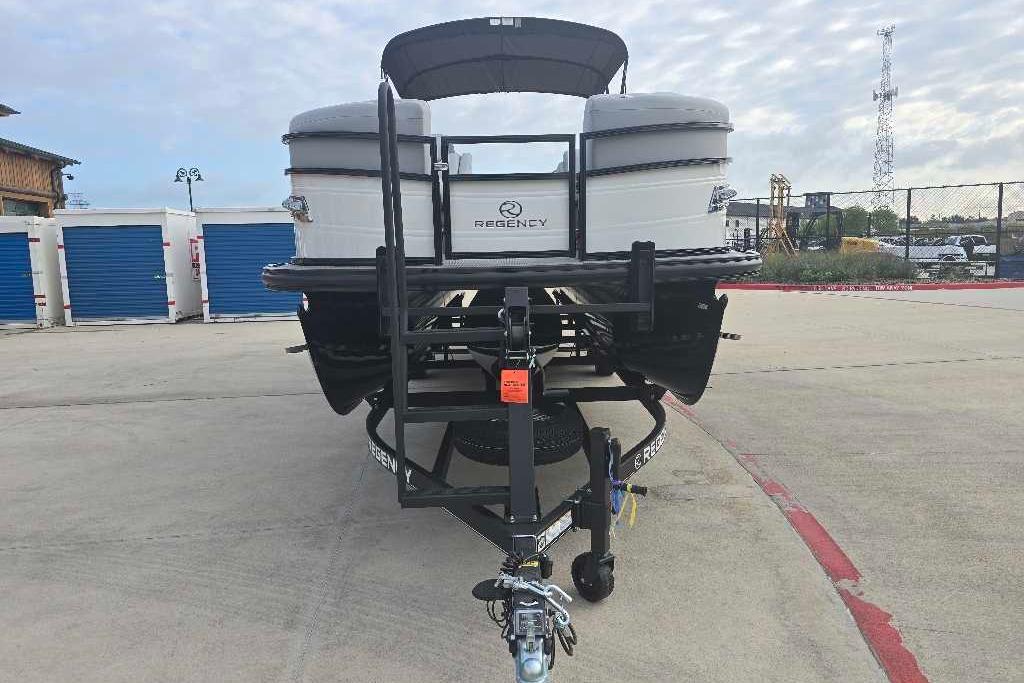 2025 Regency 250 LE3 Sport boat on trailer, parked outdoors.