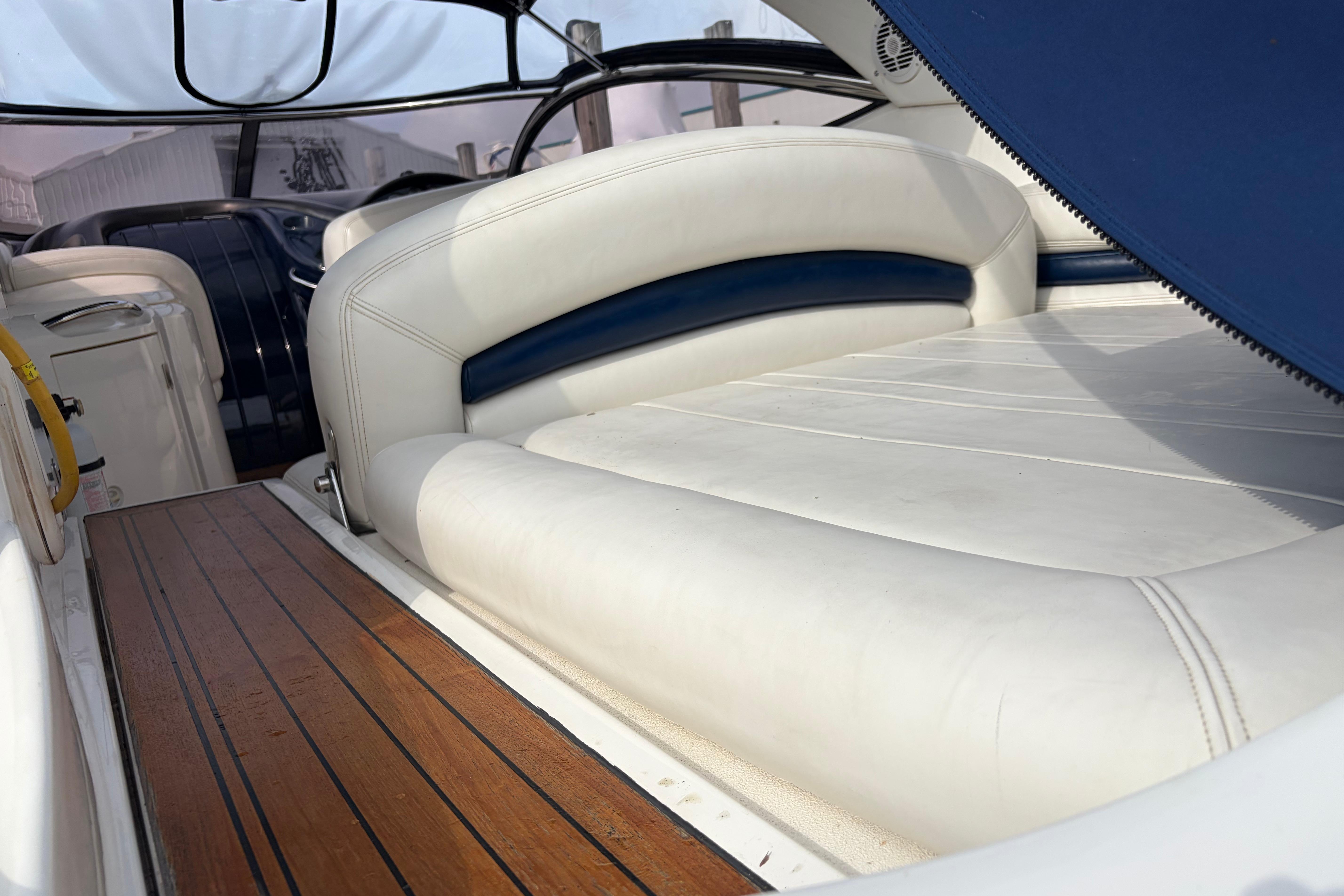Sunseeker Superhawk 34 (2000) interior with white leather seating and wooden flooring.