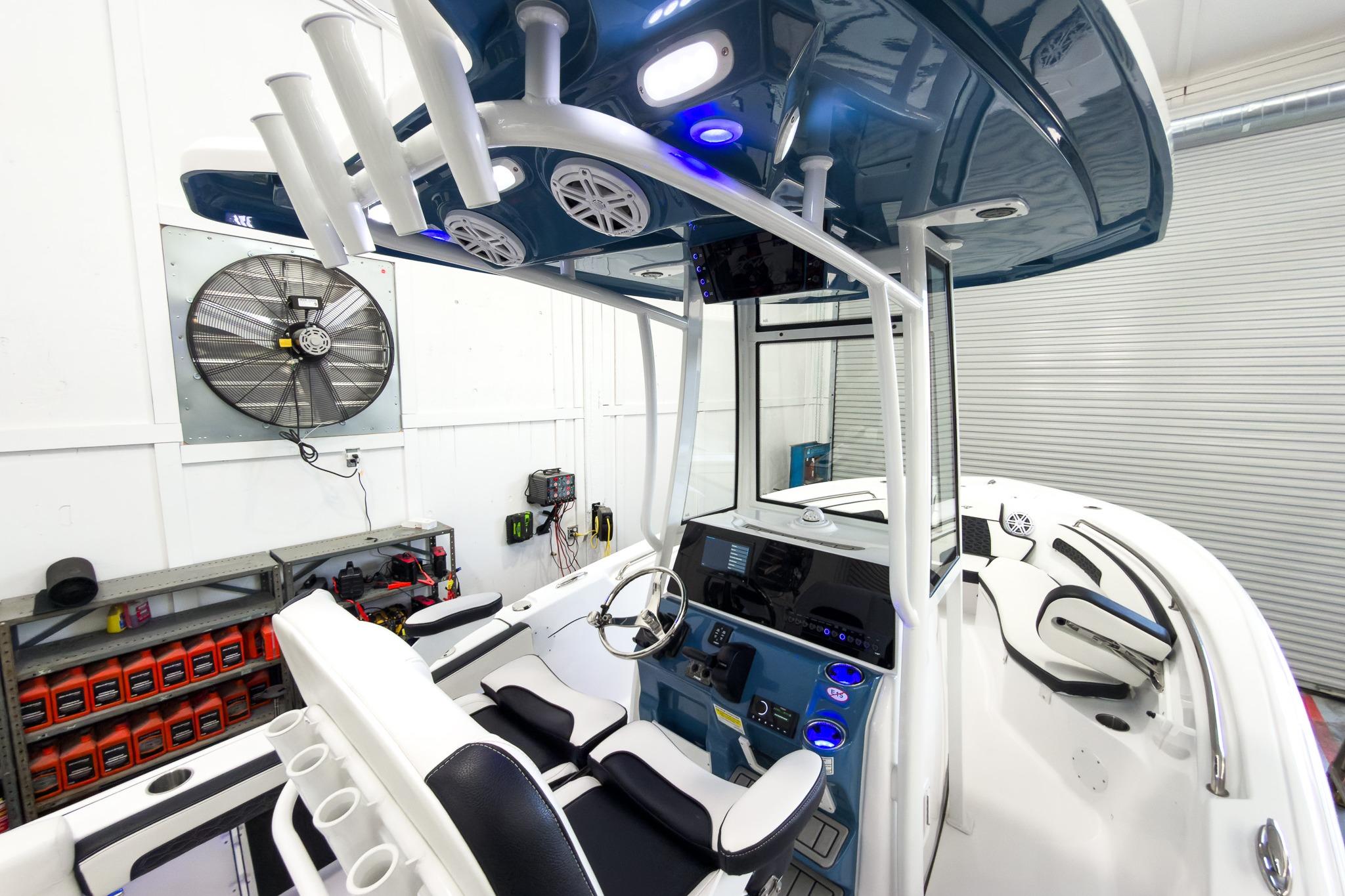 The image shows the cockpit of a Tidewater 220 LXF boat with modern controls and blue accents.