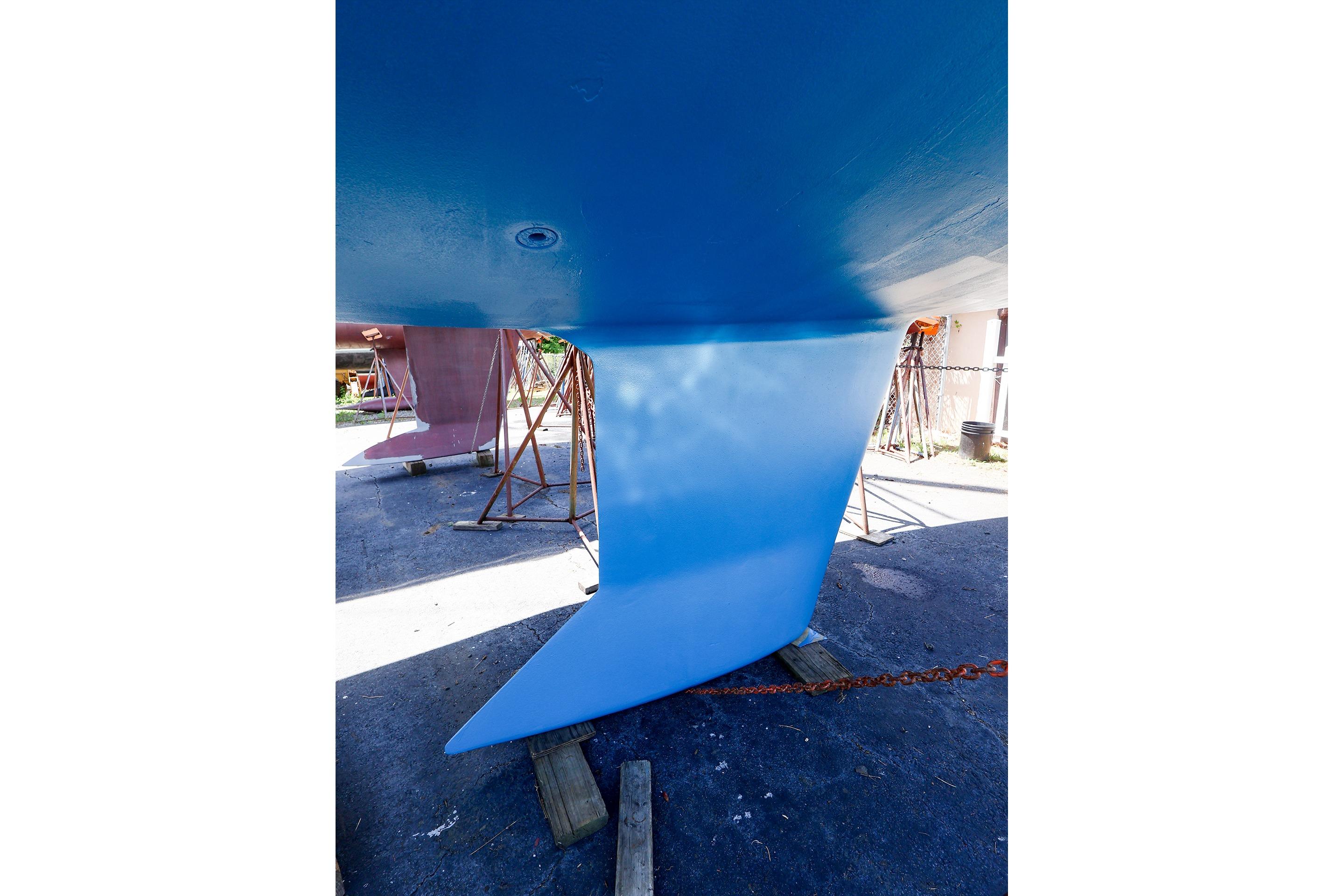 2001 J Boats J/32 sailboat keel in dry dock, showcasing blue hull and rudder.