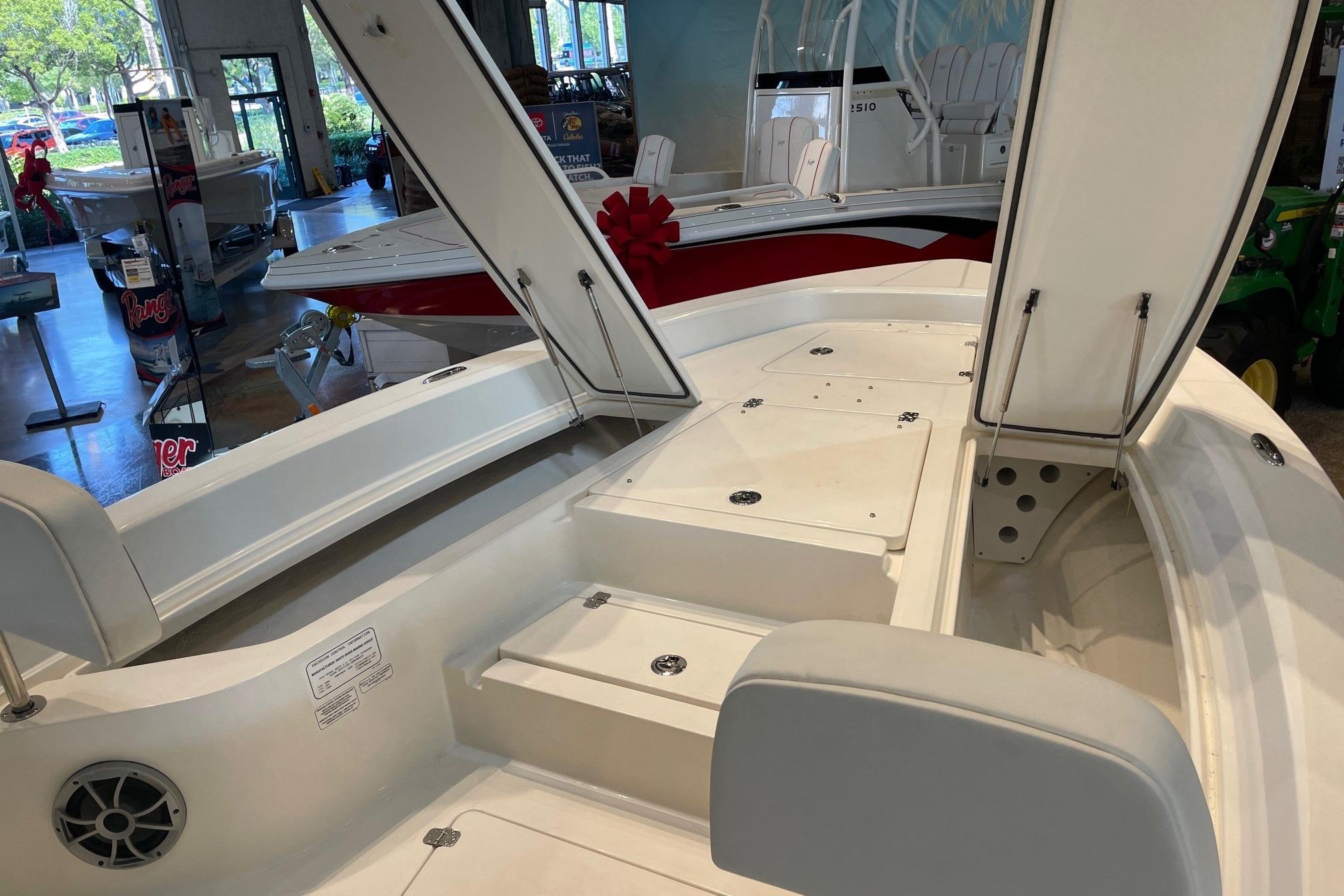 2026 Mako 24 APEX boat interior with open storage compartments in showroom.