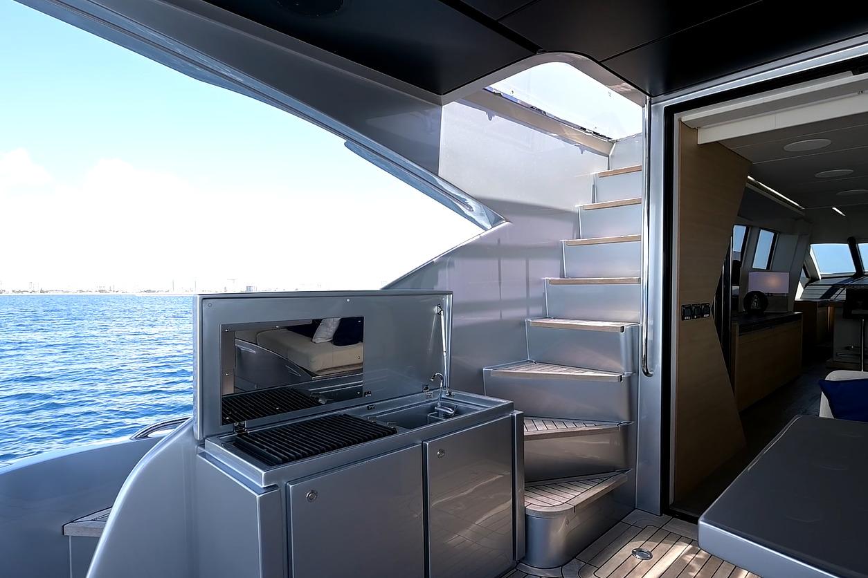 Luxurious 2015 Pershing 92 yacht interior with stairs, grill, and ocean view.