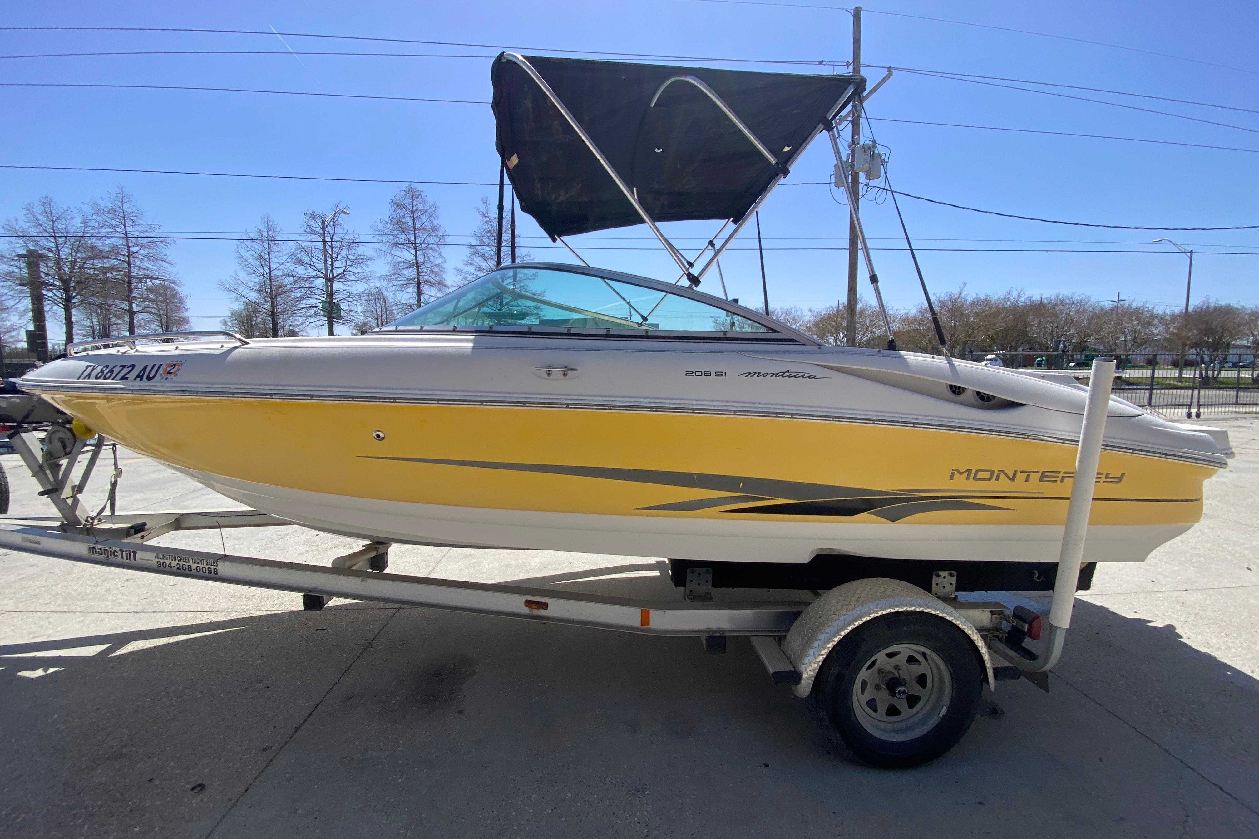 2003 Monterey 208SI Montura boat on trailer, yellow and white design, with canopy.