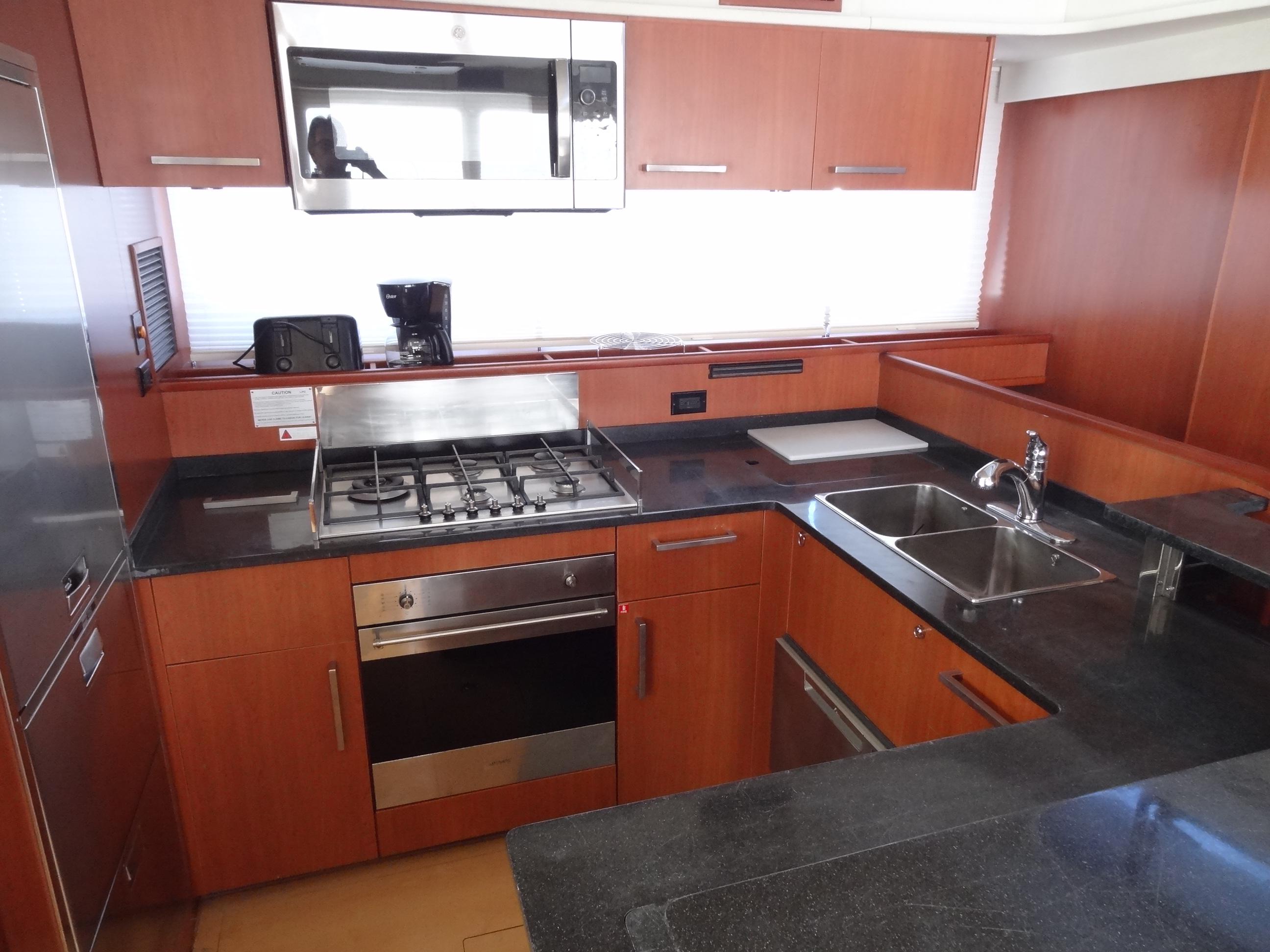 Modern kitchen in a 2014 Leopard 58 yacht with stainless steel appliances.