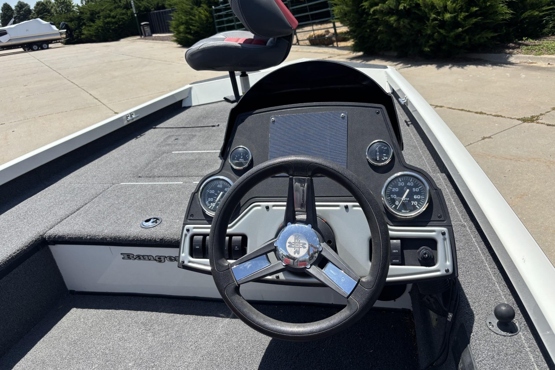 2017 Ranger RT178C boat dashboard with steering wheel and gauges in a sunny outdoor setting.