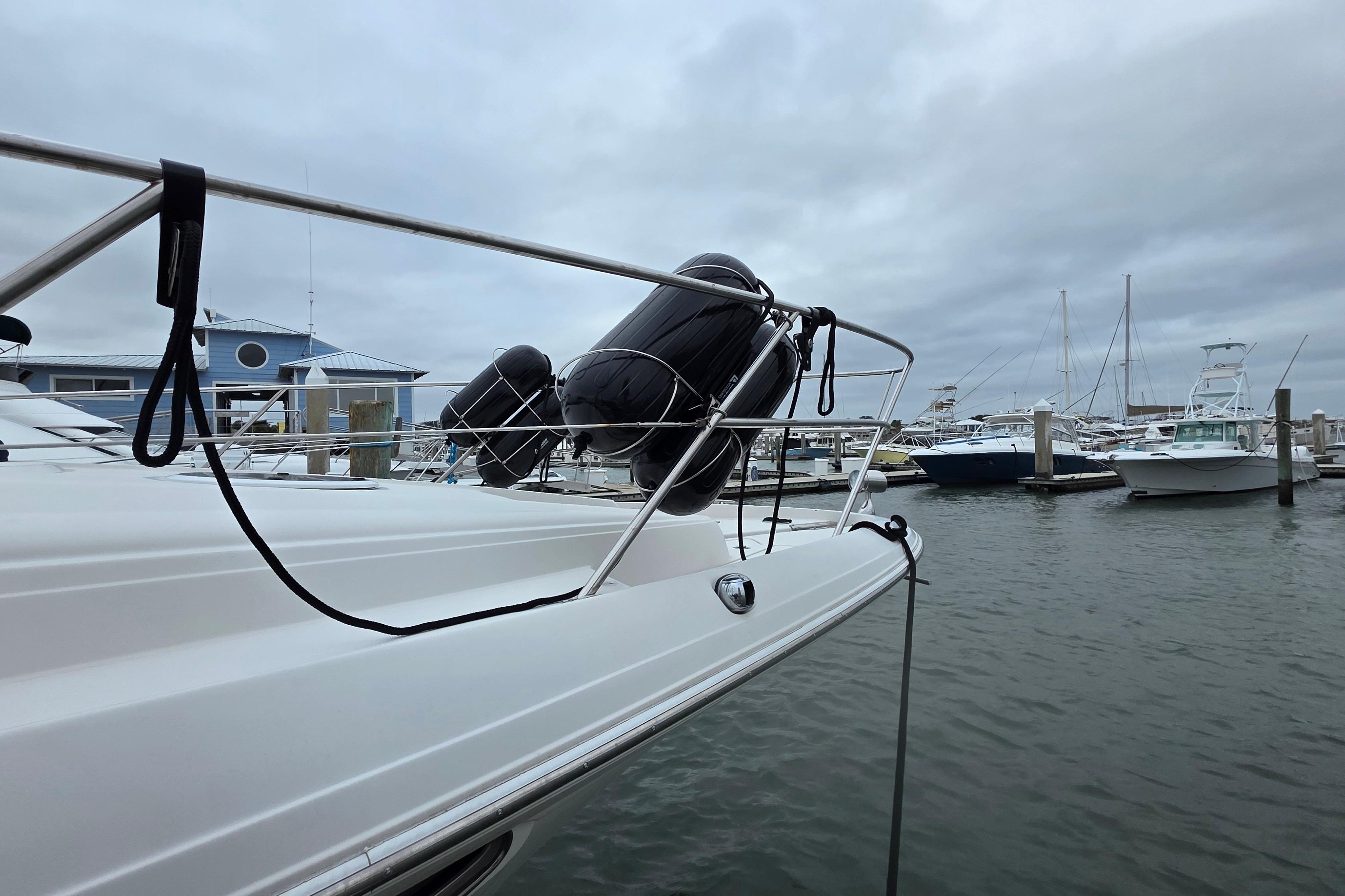 2002 Regal Commodore 4260 yacht docked at marina with cloudy sky.