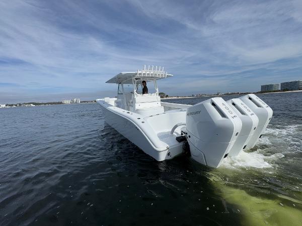 2025 Yellowfin 39 Offshore boat cruising on open water with triple outboard engines.