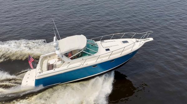 1996 Tiara Yachts 3500 Express cruising on water, blue hull, white decks.