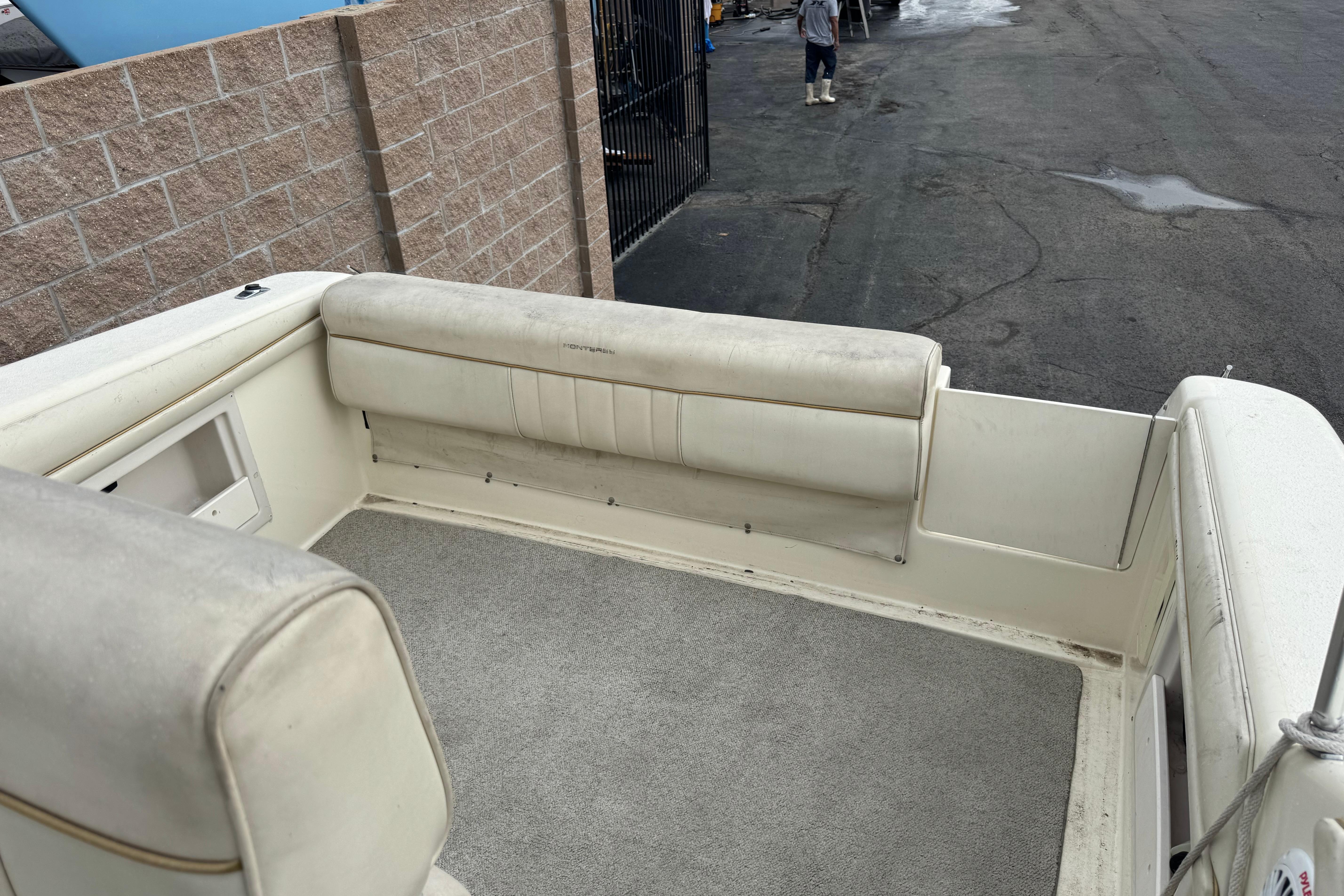 1997 Monterey 256 Cruiser boat interior with beige seating and carpeted floor.