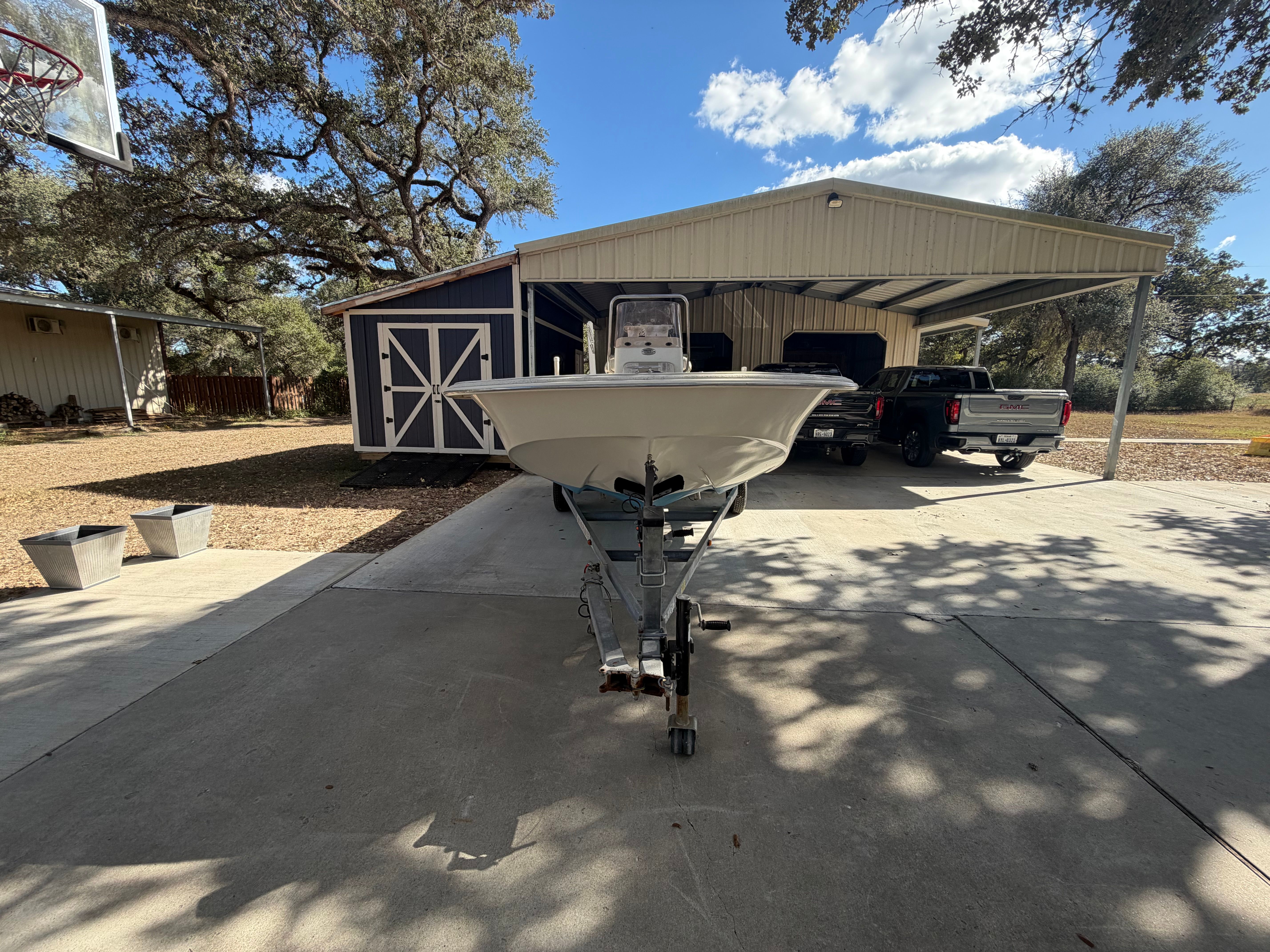 A 2016 Carolina Skiff 178 DLV on a trailer in front of a garage.