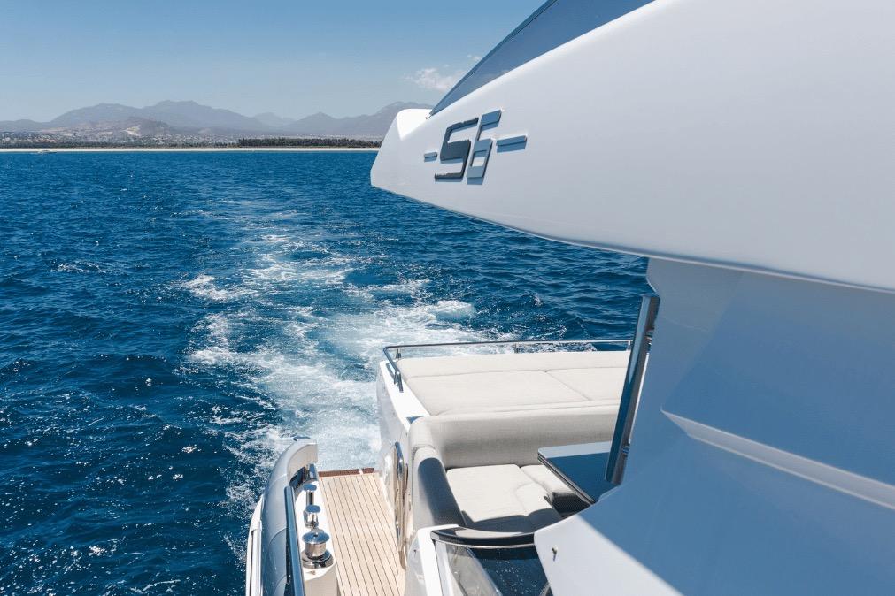 2020 Azimut 60 yacht cruising on open blue sea with distant mountains.