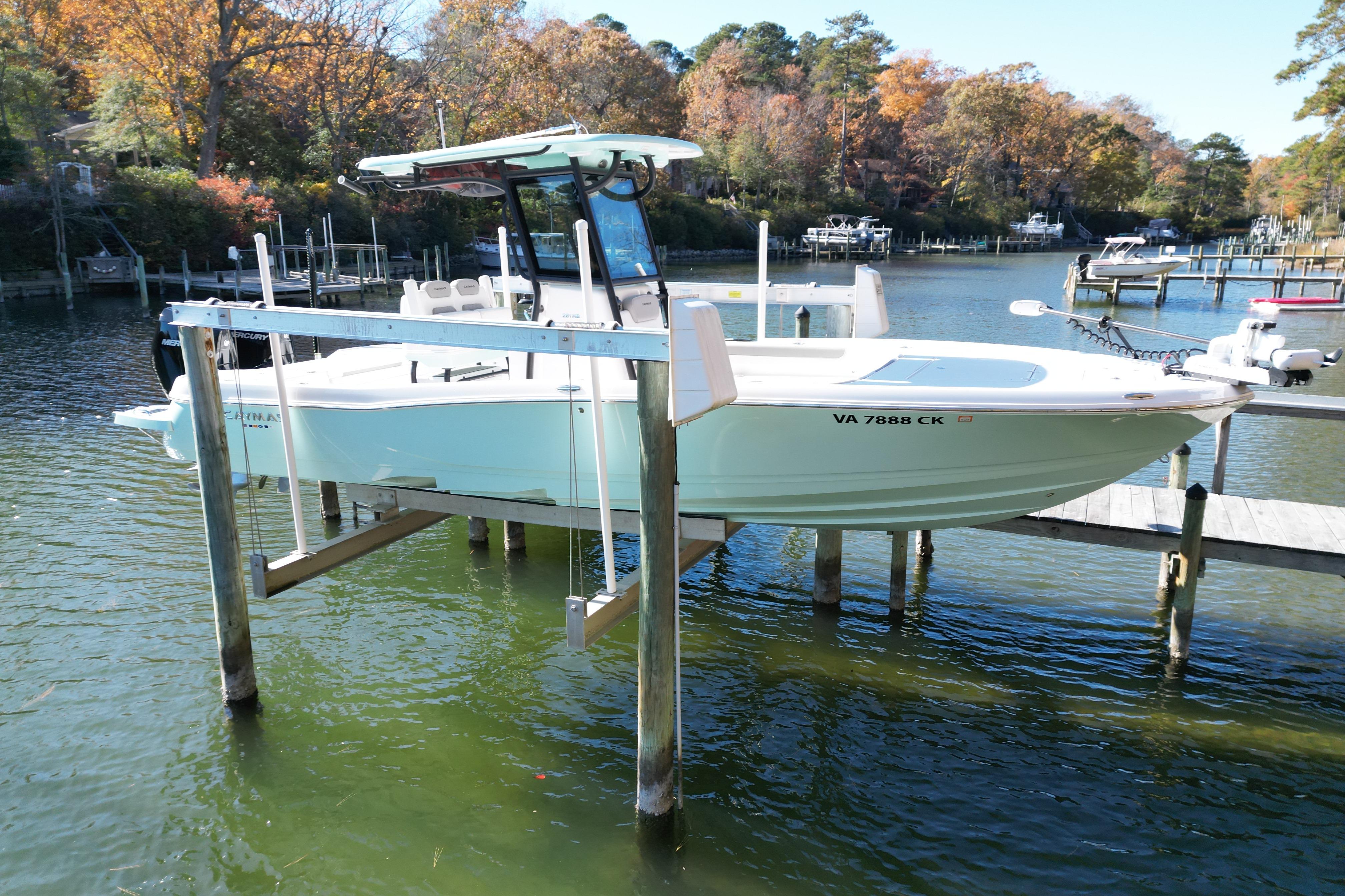 2023 Caymas 281 HB boat on lift, docked in scenic autumn marina.