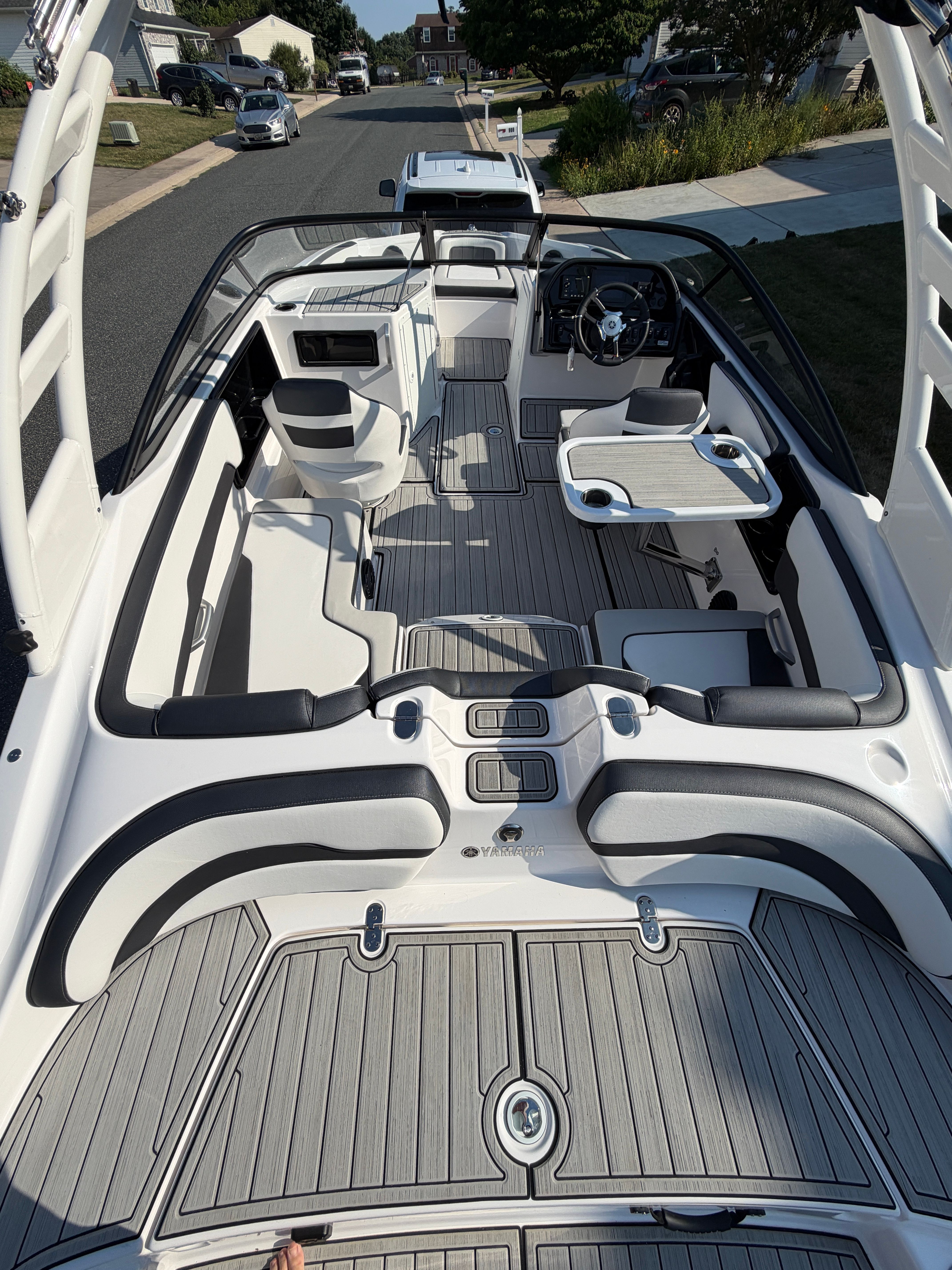 The image shows the interior of a 2023 Yamaha 195S boat with modern seating and a helm.