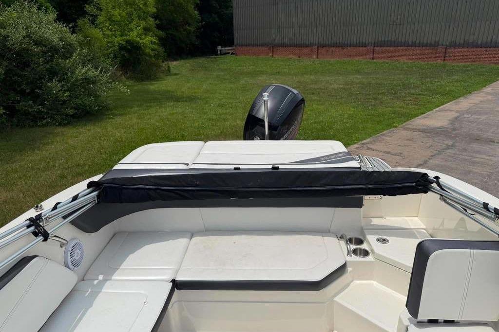 2016 Sea Ray 21 SPX boat interior with seating and outboard motor, parked on grass.