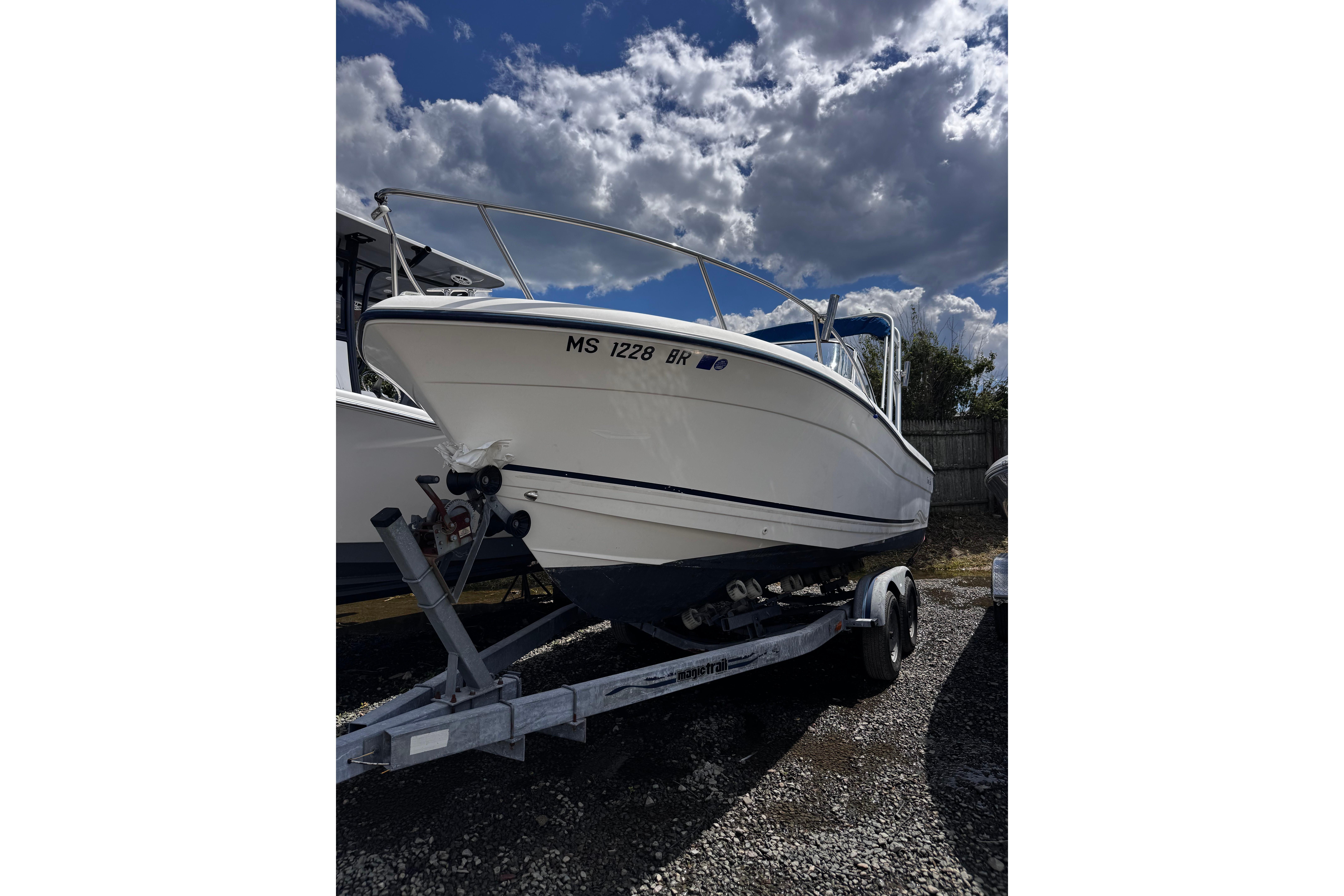 2003 Palm Beach 2200 Dual Console boat on trailer under cloudy sky.