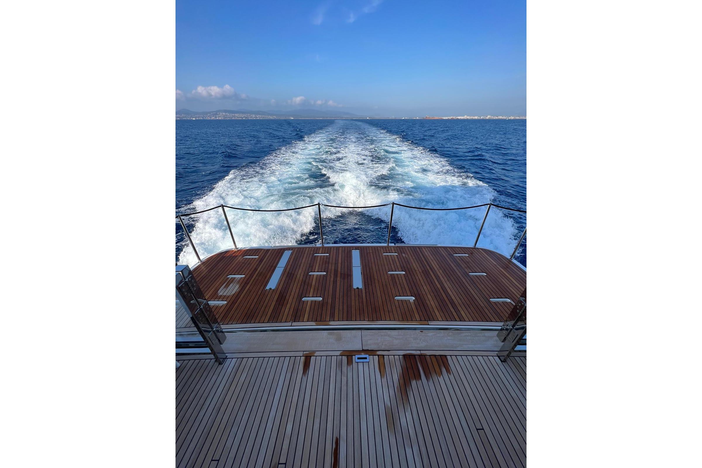 Rear view of 2024 Prestige M8 yacht cruising on open sea.