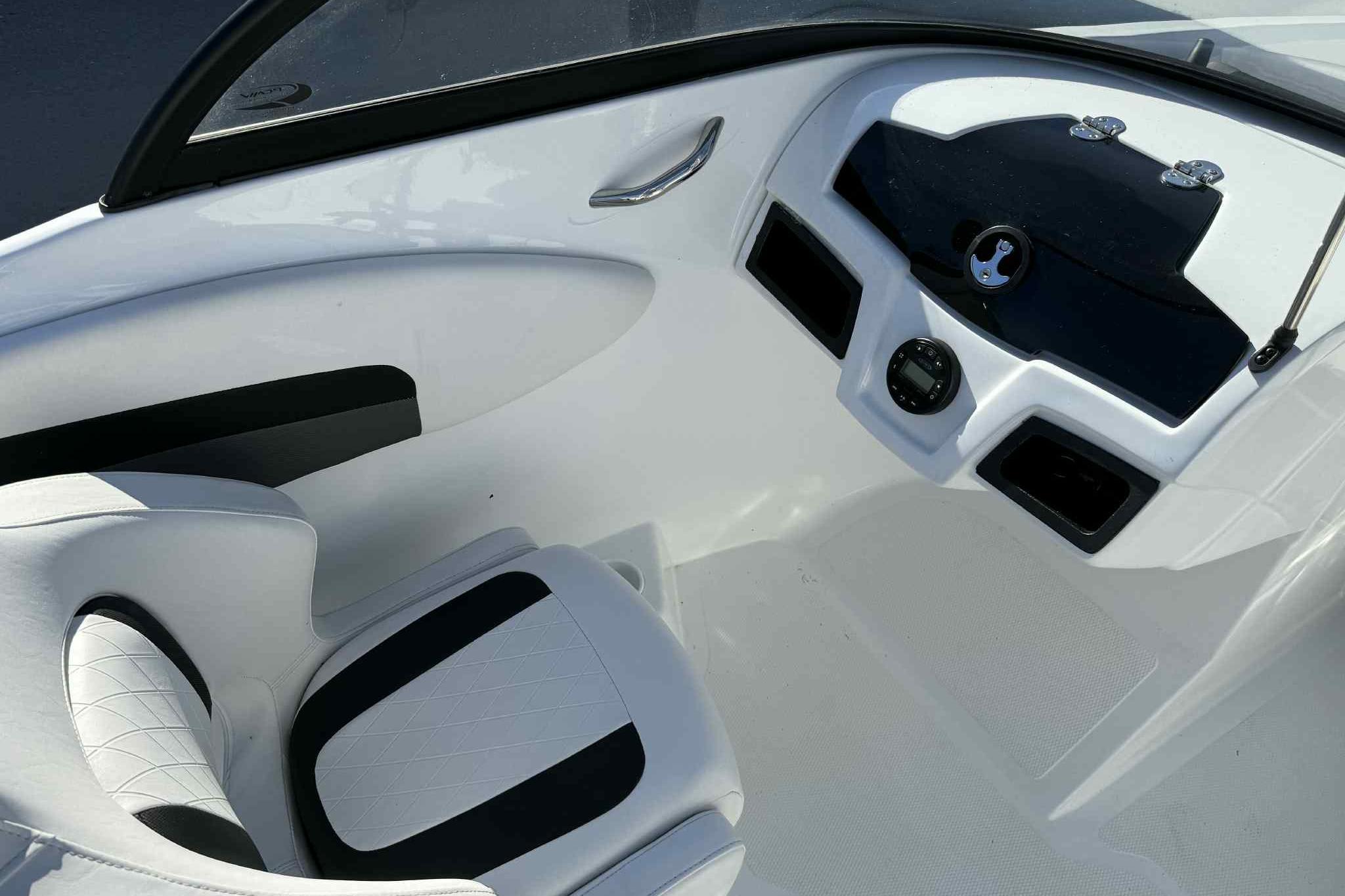 Interior of 2021 Tahoe 550 TS boat, featuring sleek white and black seating and dashboard.