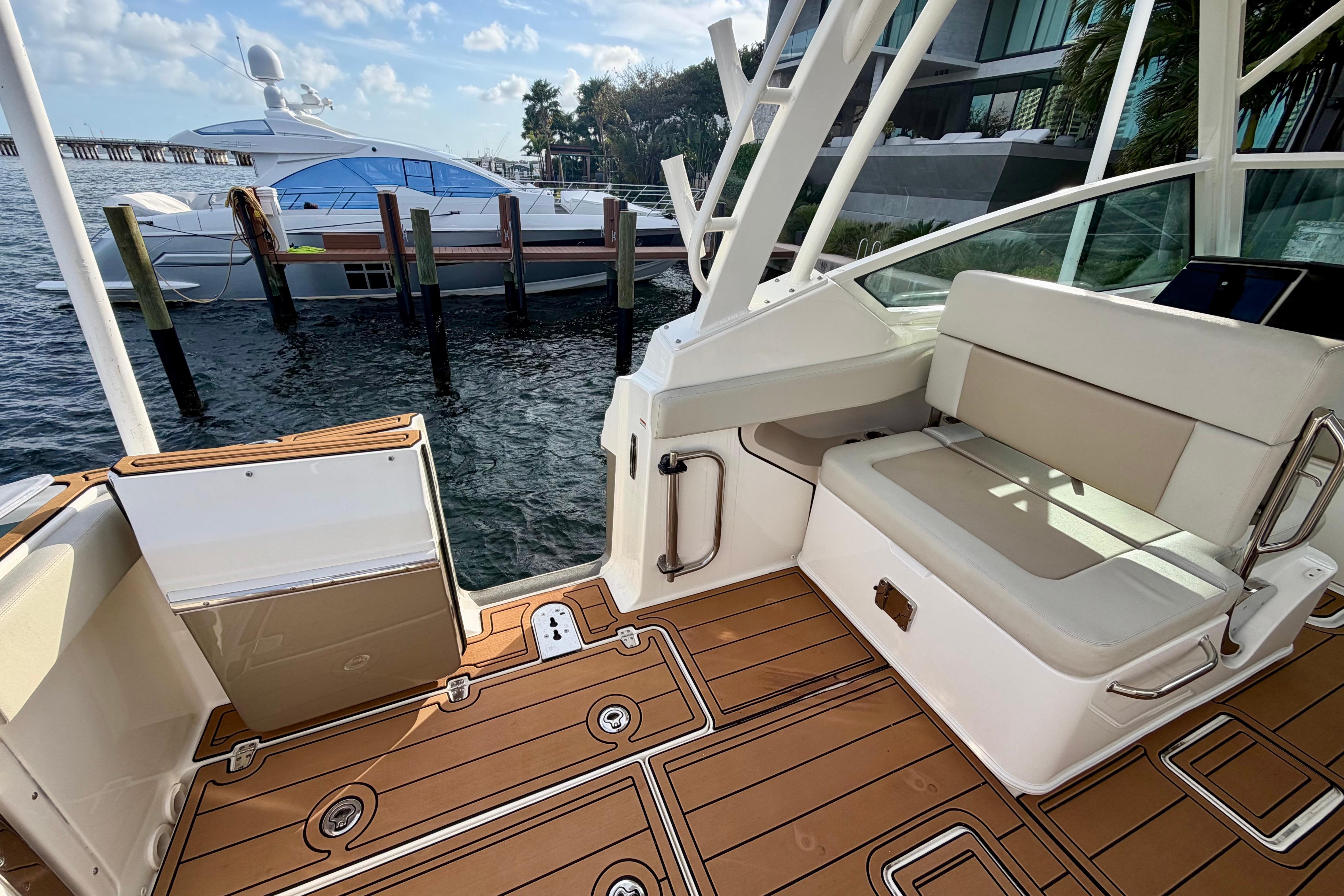 2022 Boston Whaler 280 Vantage boat interior with seating and teak flooring, docked by the water.