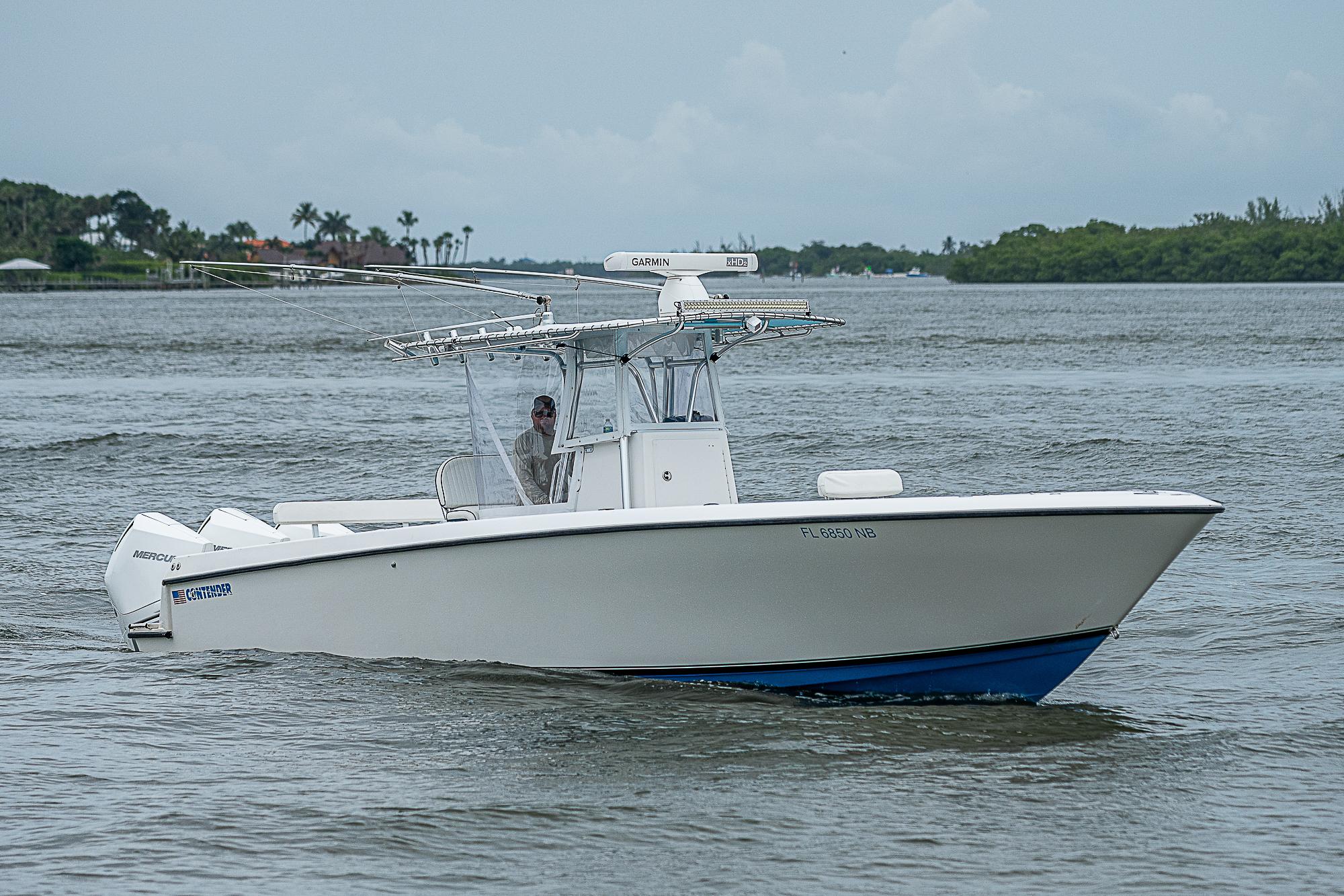 2004 Contender 36 Open boat cruising on a calm waterway.
