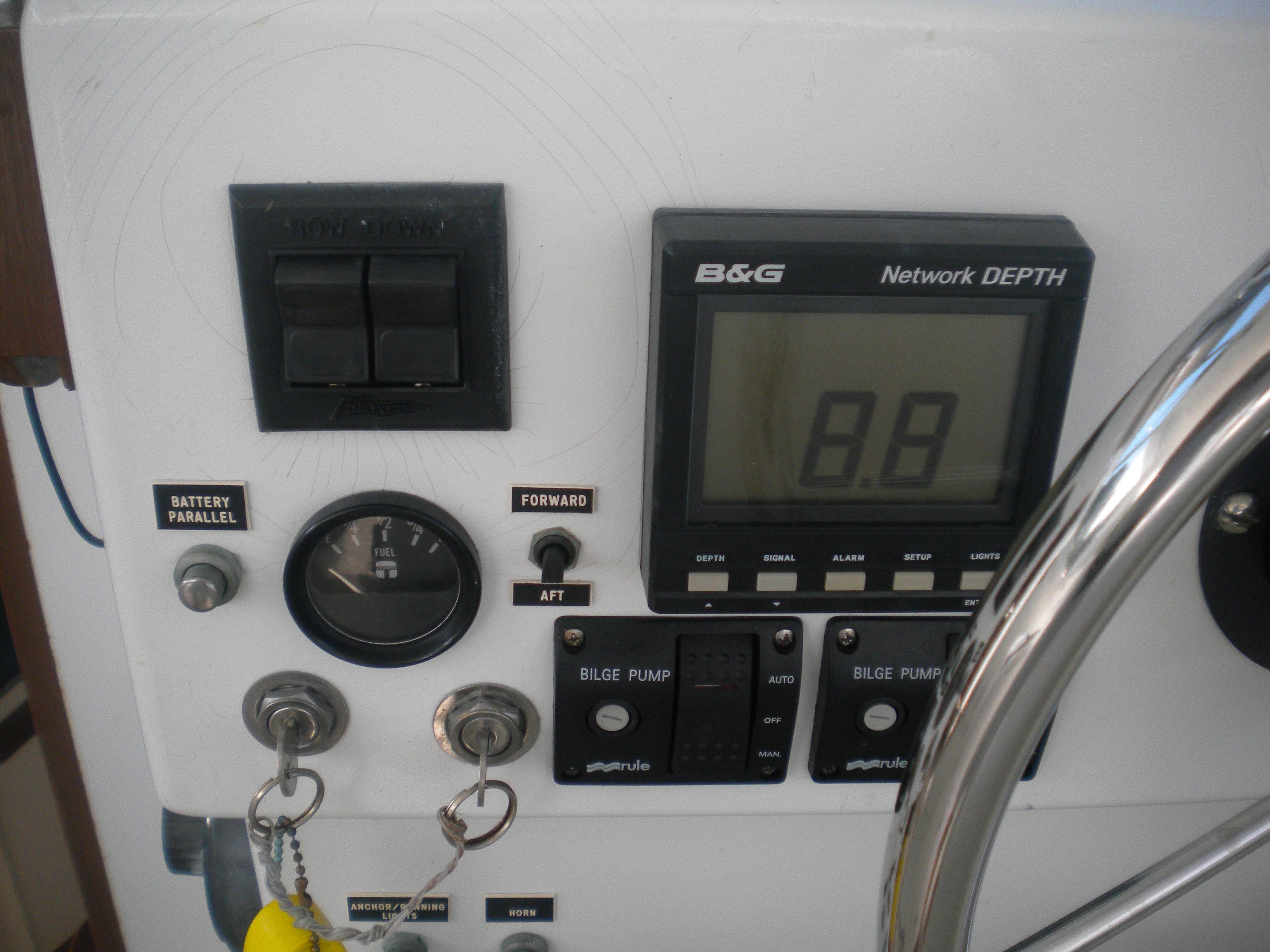 Control panel of a 1968 Bertram 31 Bahia Mar boat with depth gauge and switches.