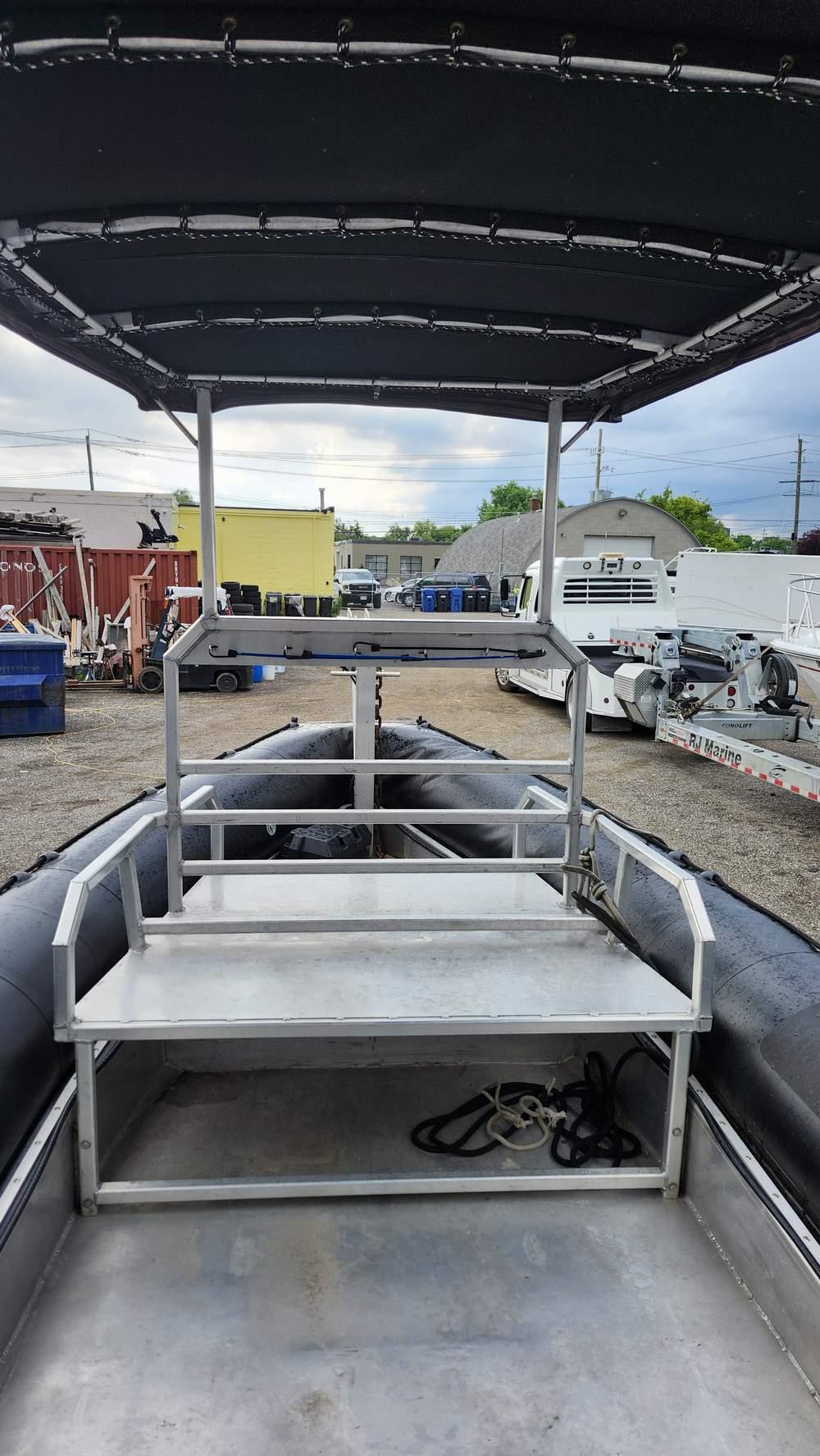 2006 Airsolid 26 Dive Boat with canopy, docked in an industrial area.