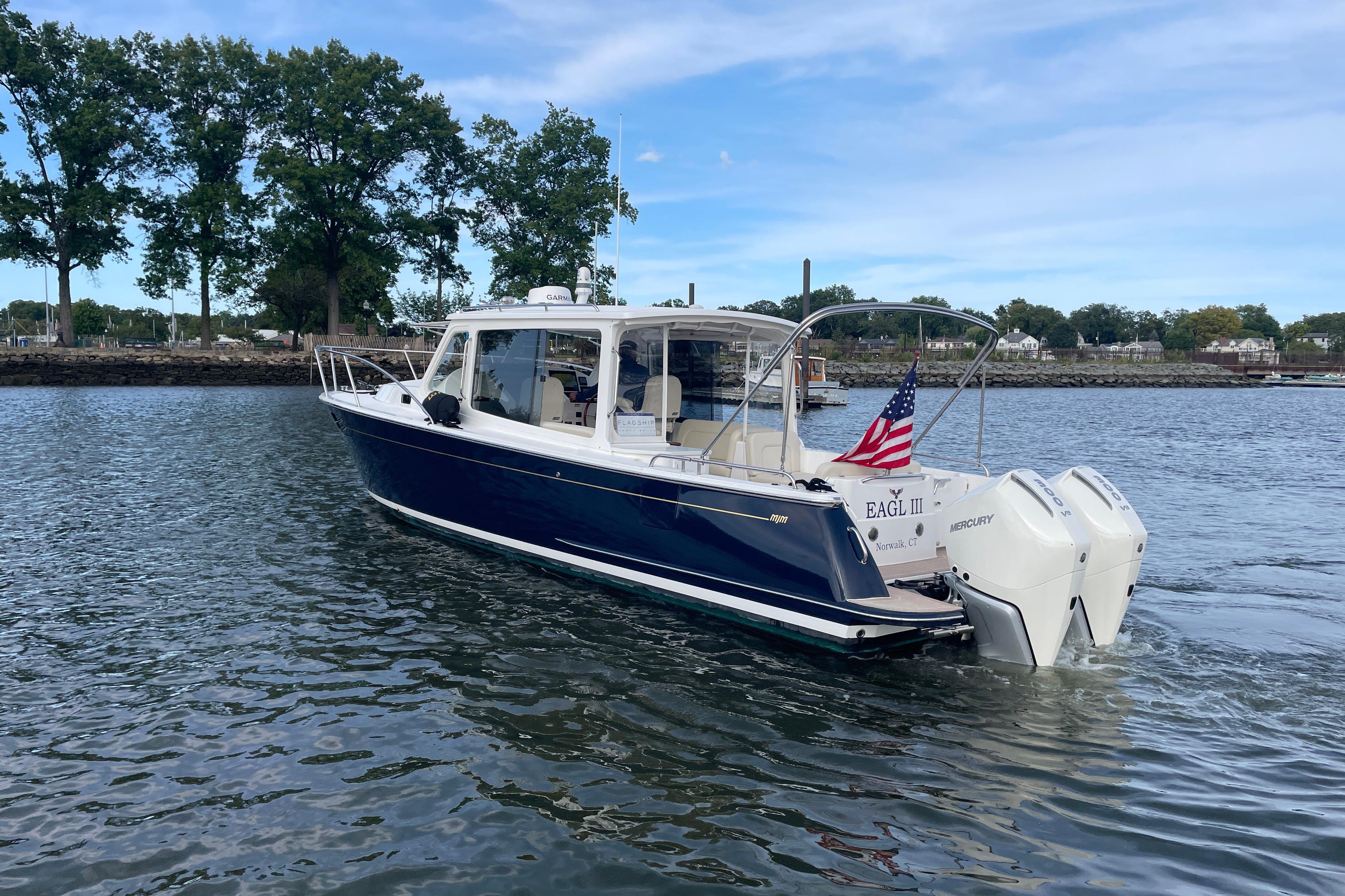 2023 MJM 35 boat cruising on a calm lake with American flag.
