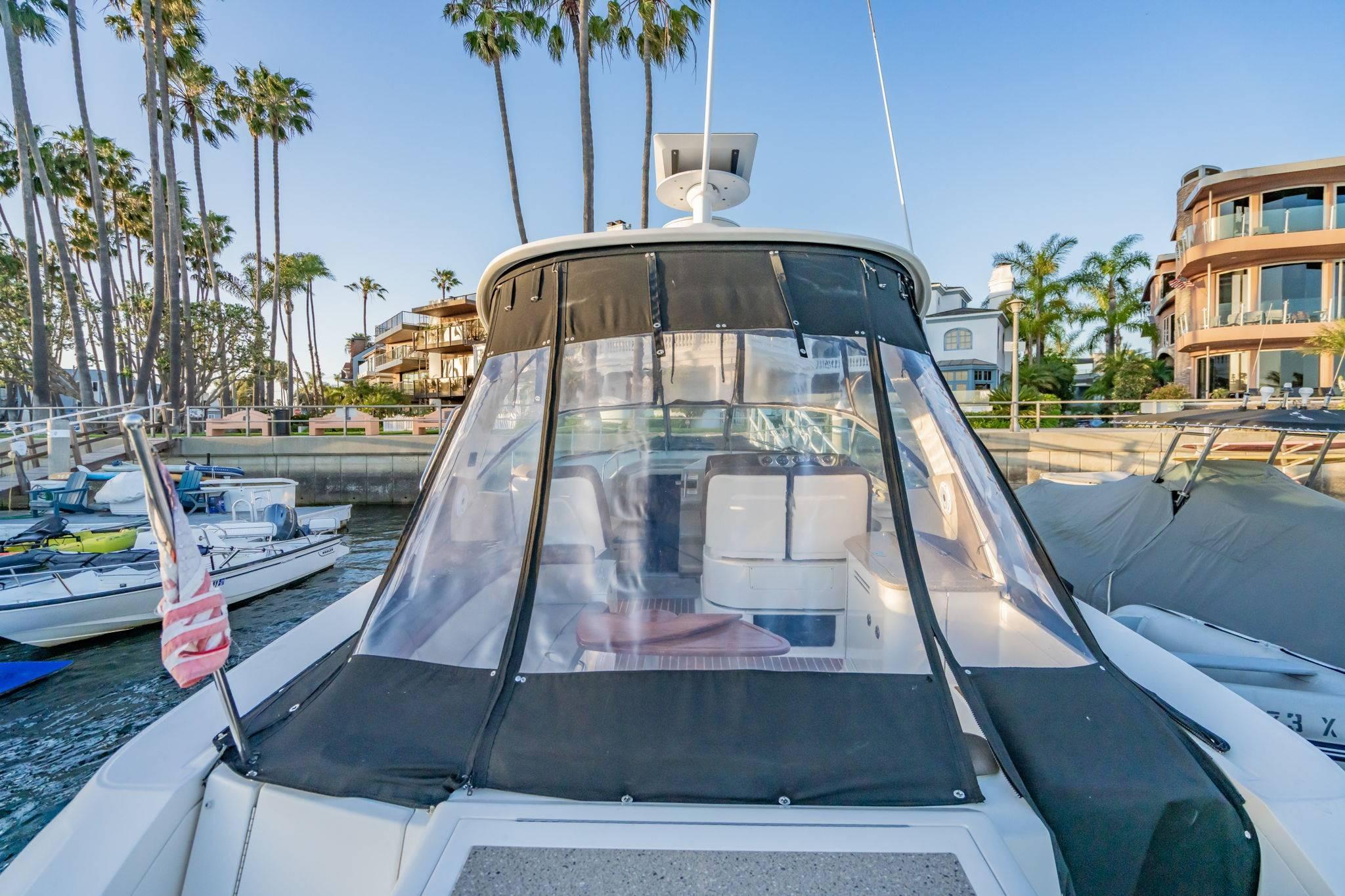 2016 Sea Ray 370 Express Cruiser docked near palm trees and waterfront homes.