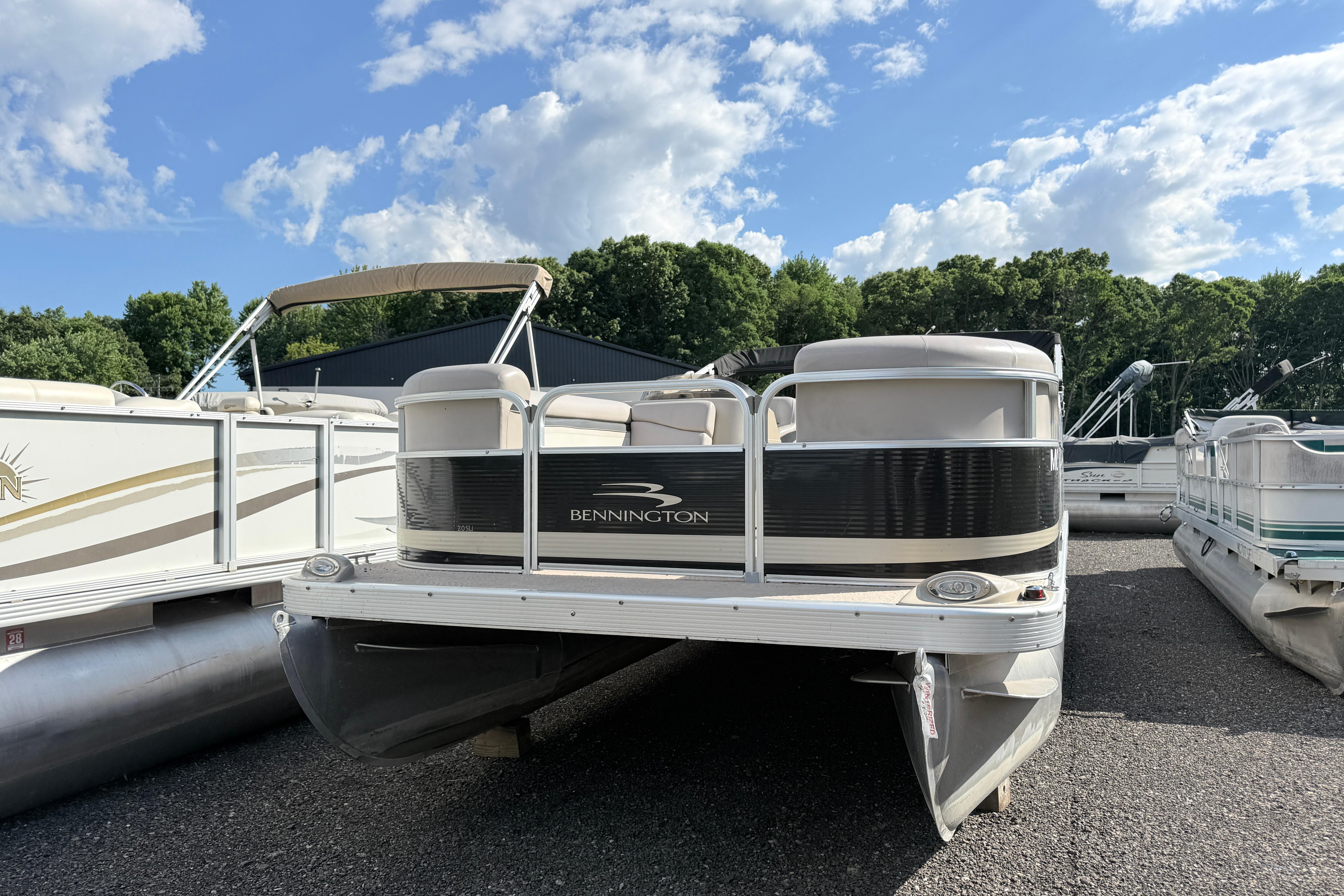 2010 Bennington 20SLi pontoon boat parked outdoors under a blue sky.