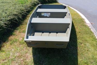 2026 Tracker Grizzly 12 Jon boat on grass, showcasing interior seating and design.