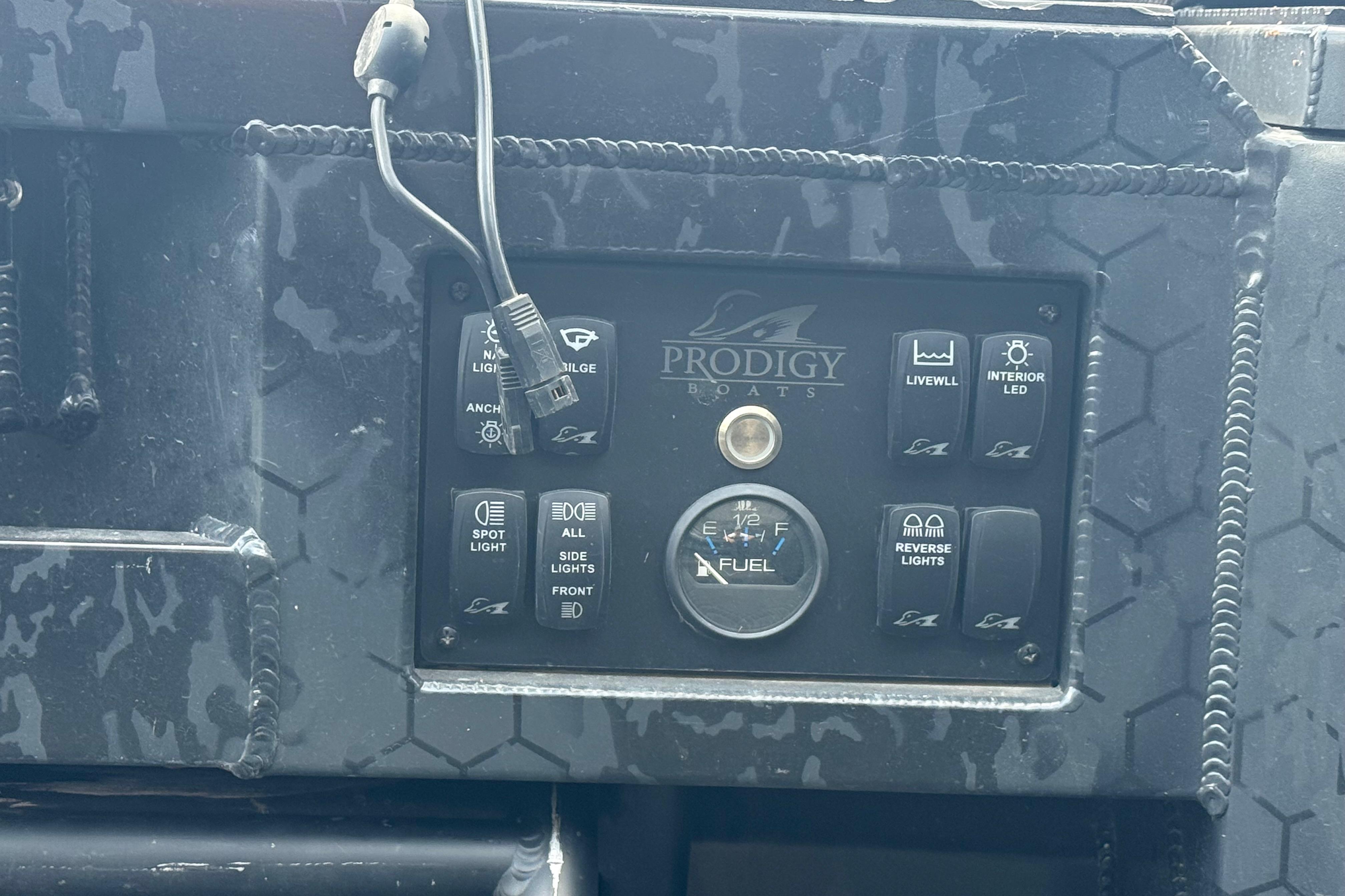 Control panel of a 2024 Prodigy 17 boat with various switches and fuel gauge.