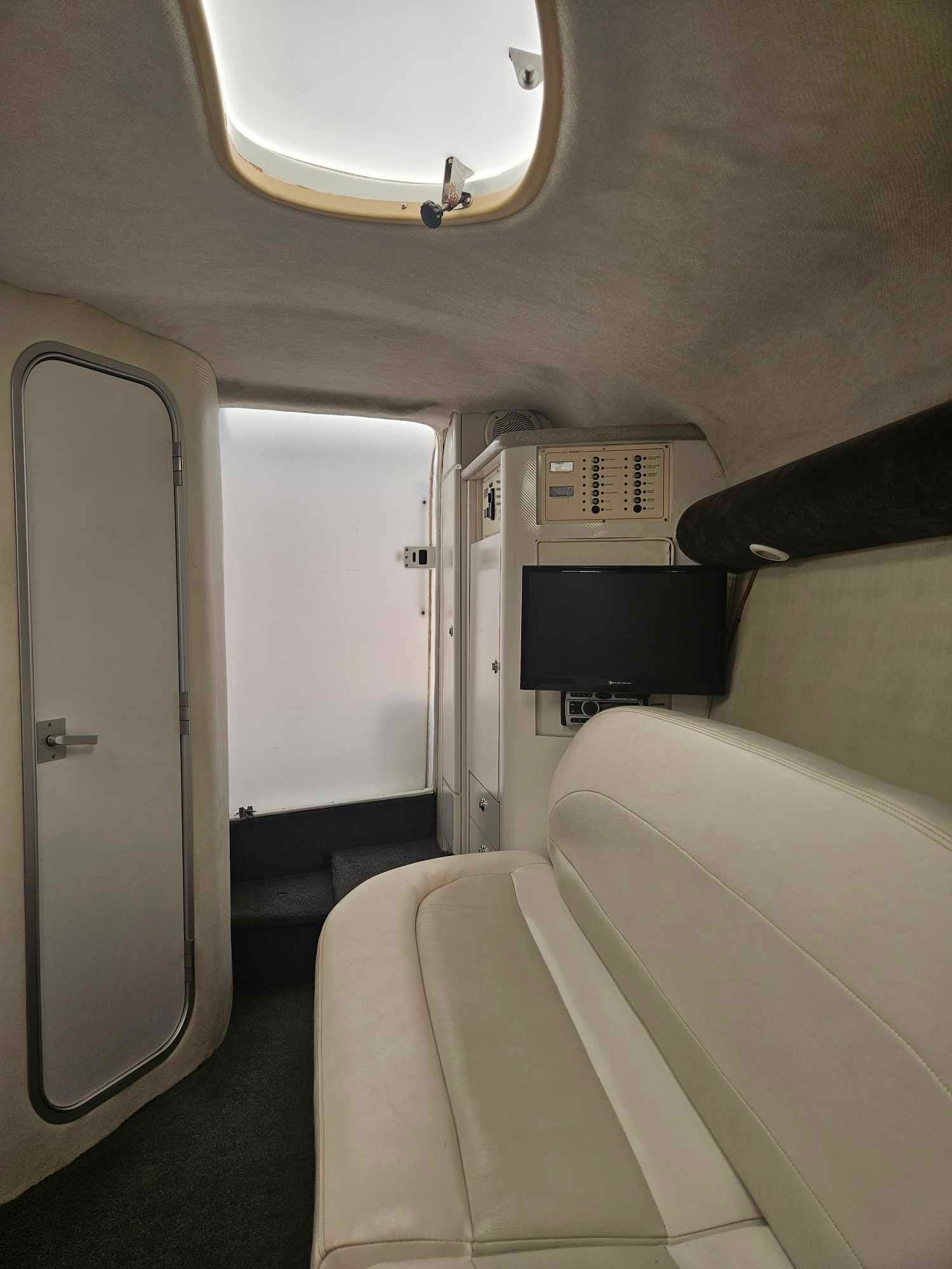 Interior of a 1997 Baja 38 Special Boss boat with sofa and TV.