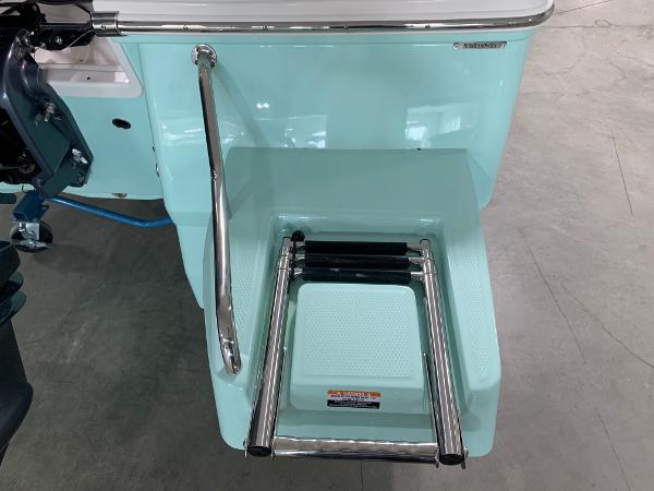 2026 Robalo 226 Cayman boat with a stainless steel swim ladder and teal finish.